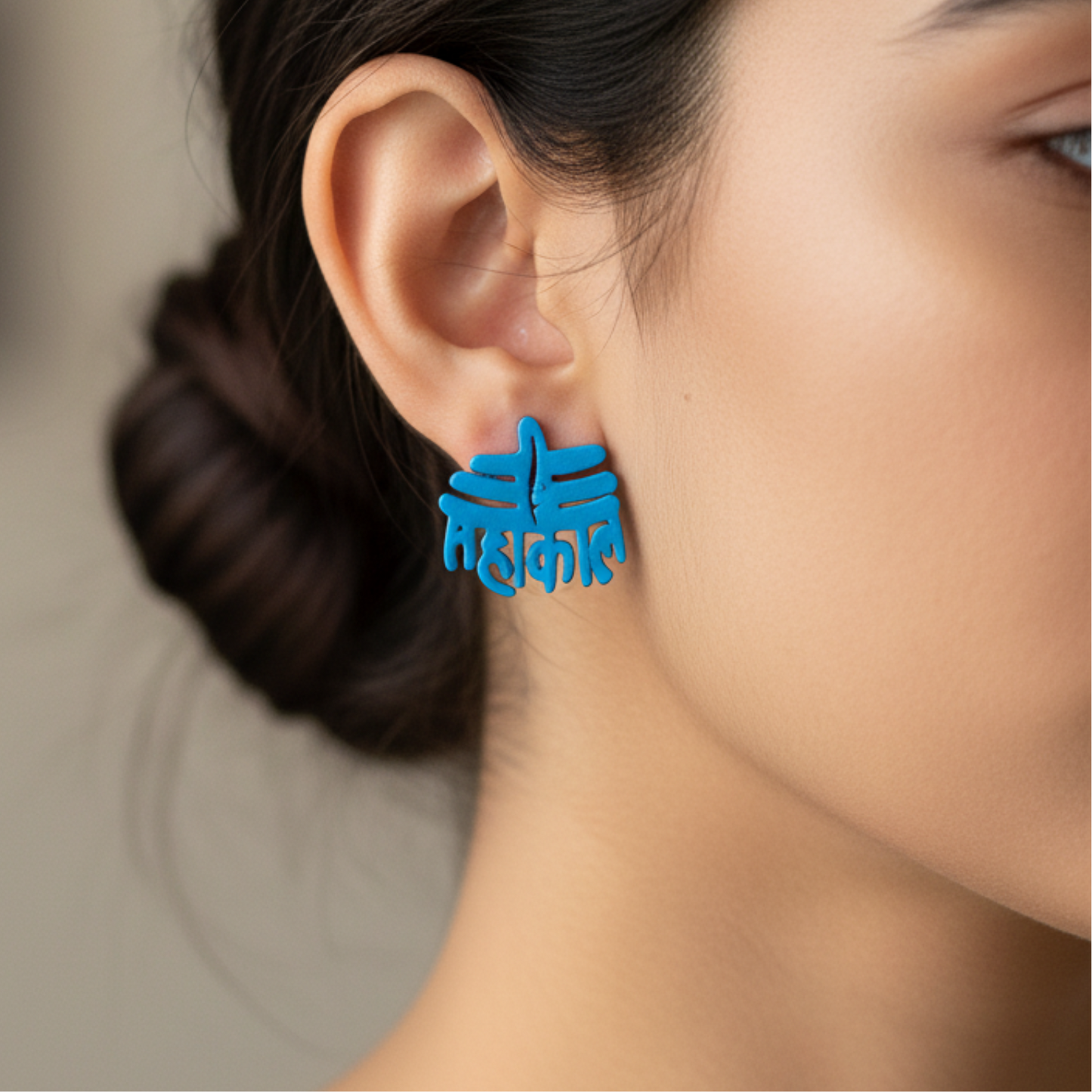 Blue earrings worn by a person with a neutral background