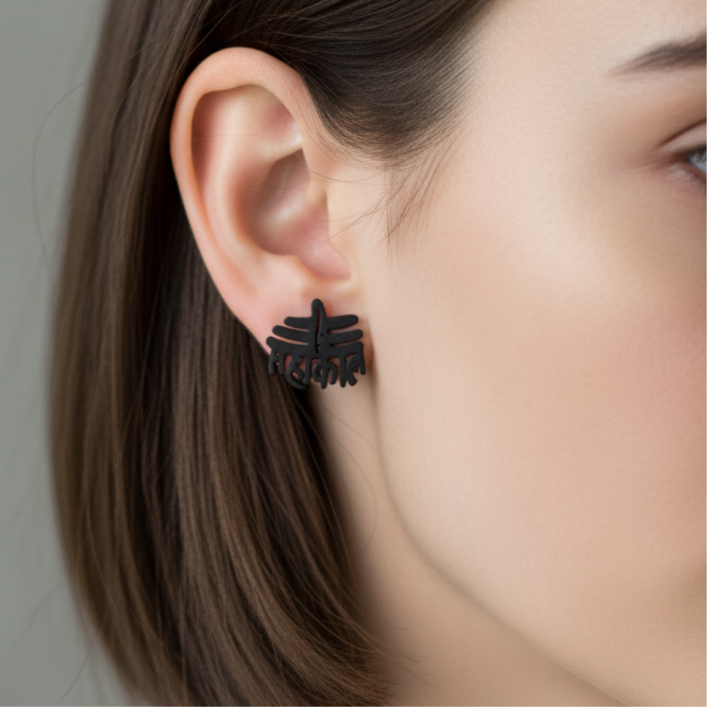 Black earrings worn by a person with a neutral background