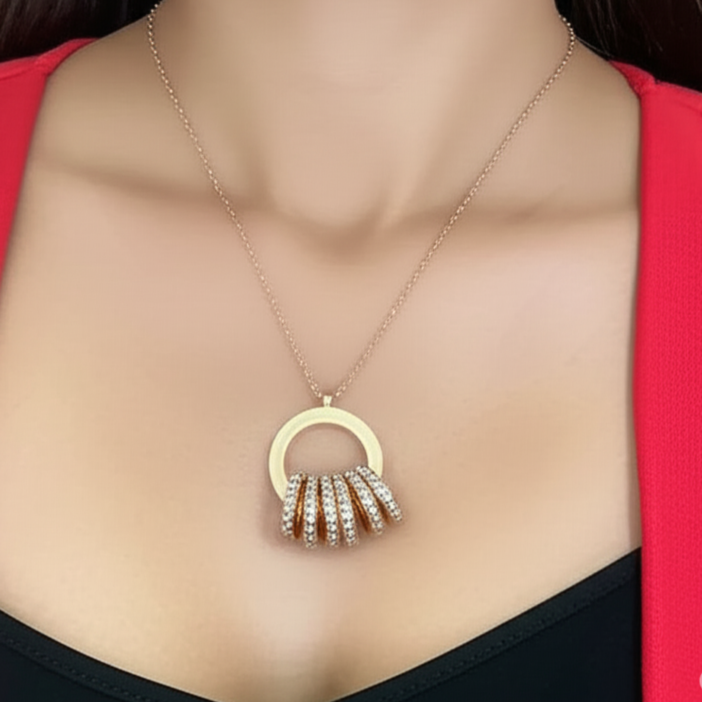 Gold necklace with a circular pendant on a mannequin wearing a red top.