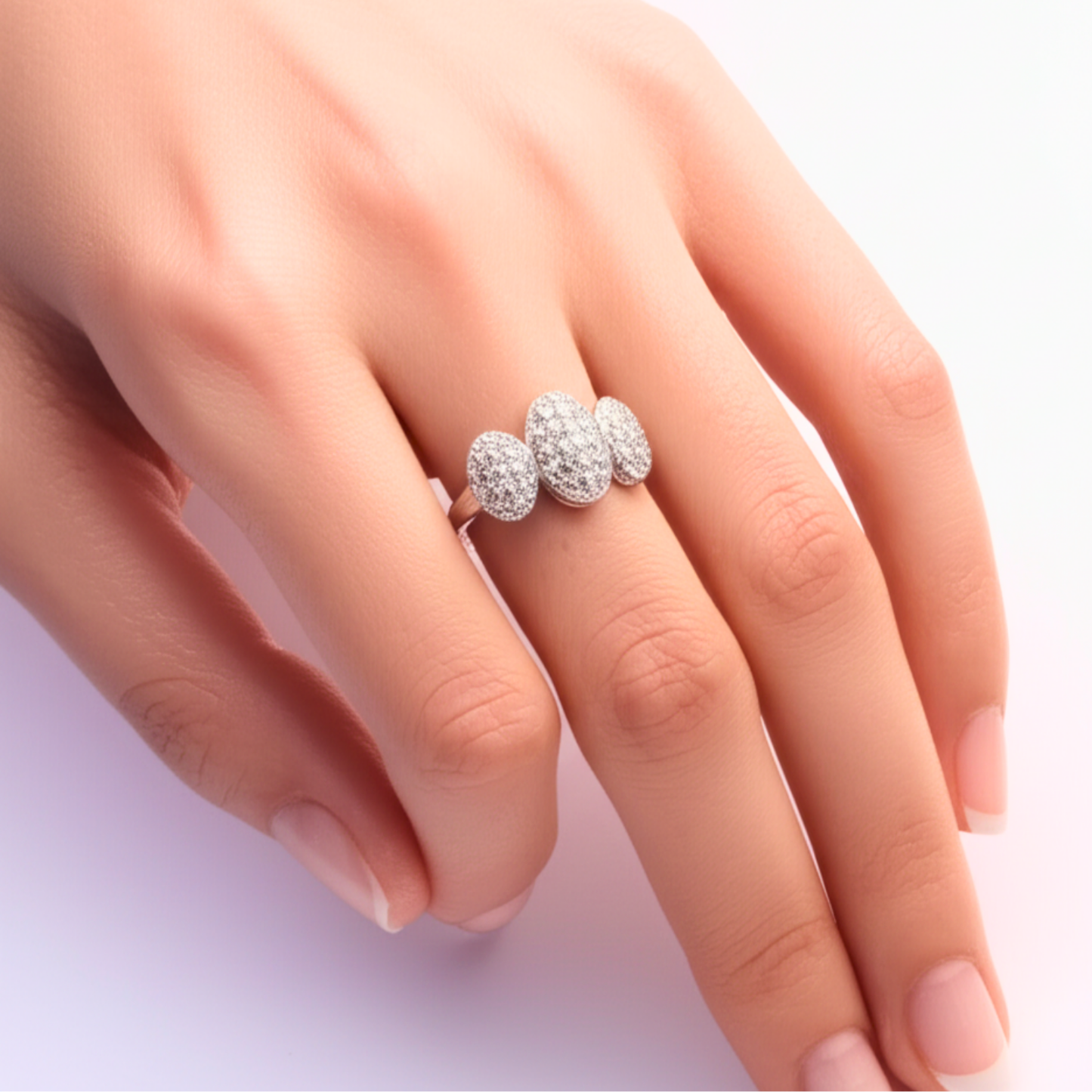 Silver ring with three round diamonds on a hand against a light background