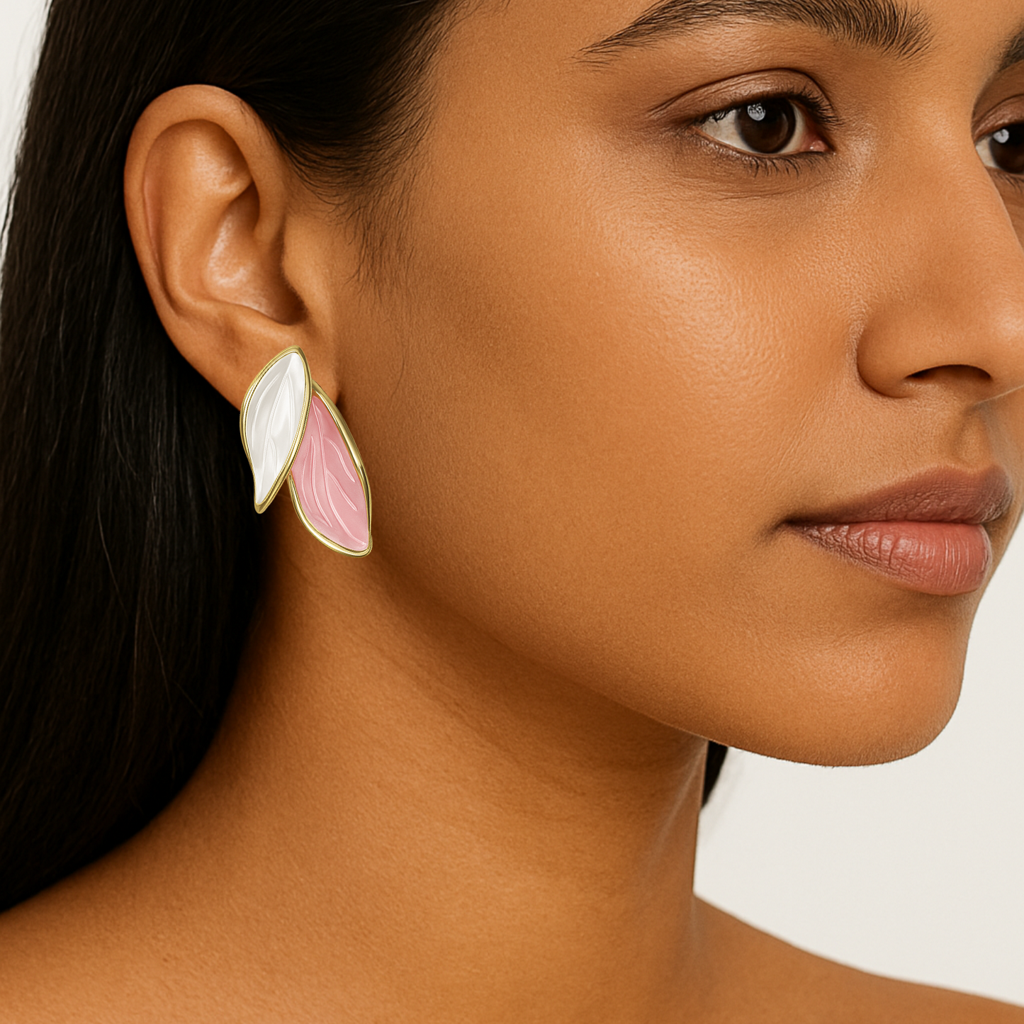 Close-up of a woman wearing a floral earring with a white and pink design.