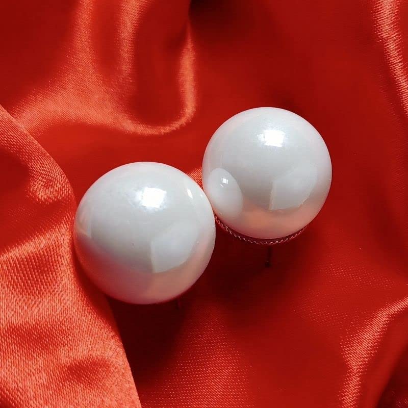 Two white spherical objects on a red fabric background