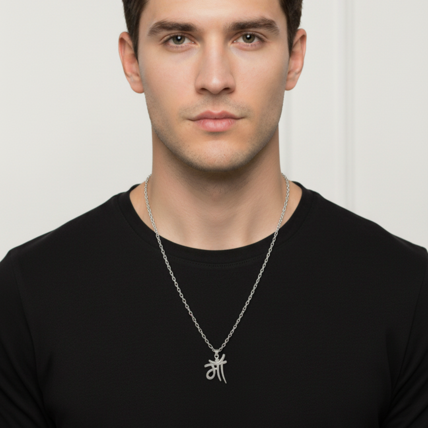 Man wearing a black shirt with a silver necklace featuring a symbol on a white background