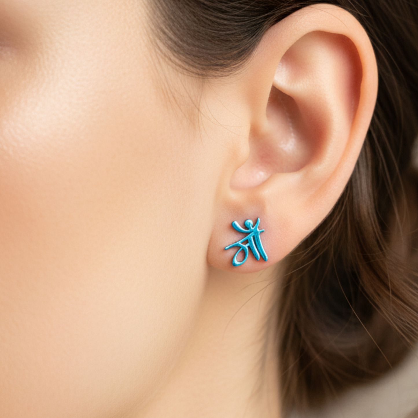Close-up of an ear wearing a blue earring with a unique design.