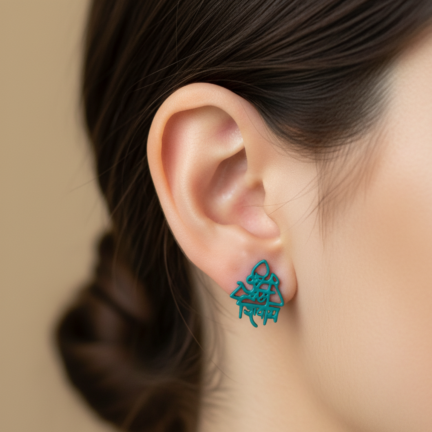 Teal earrings worn by a person with a blurred background