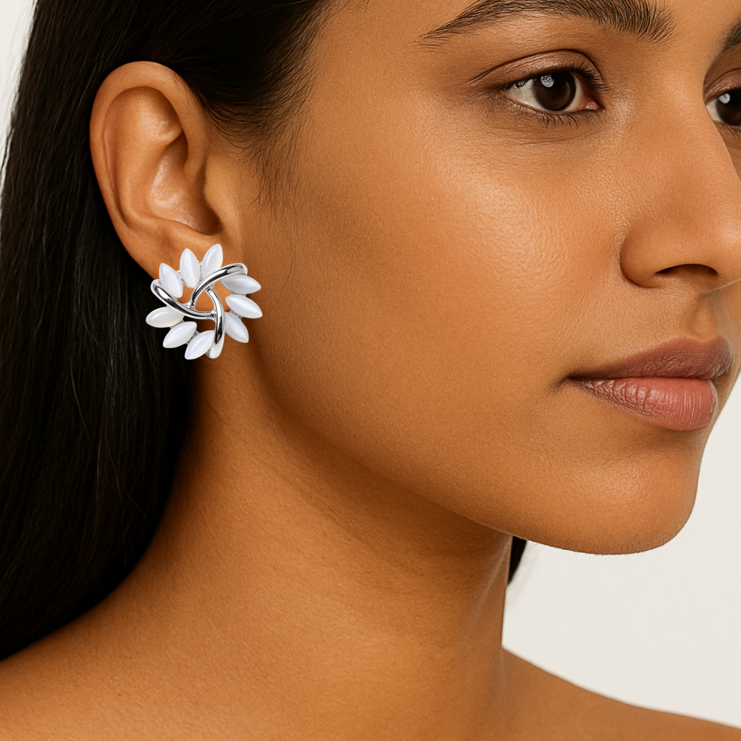 Close-up of a woman wearing a floral earring with a neutral background