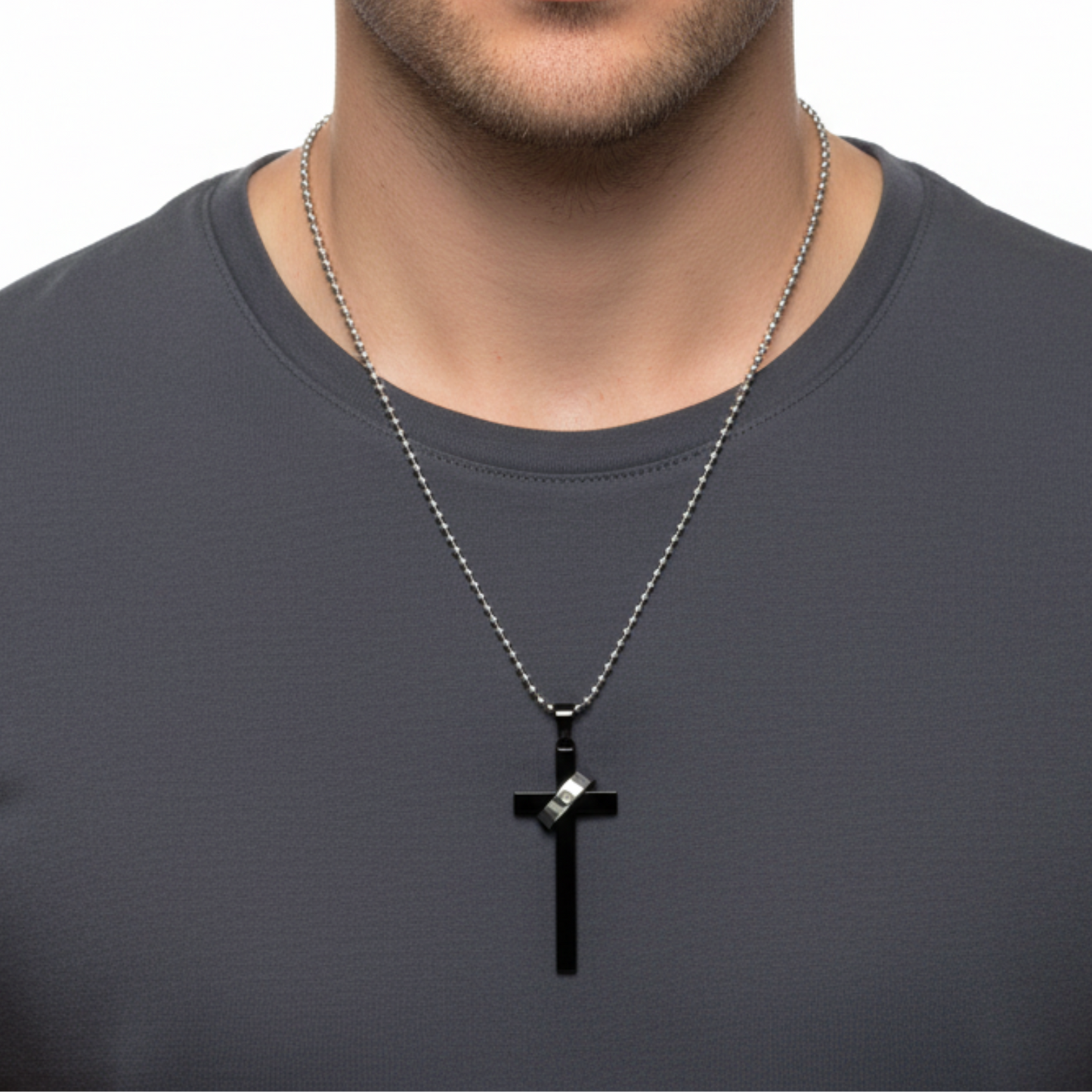 Man wearing a black cross necklace on a plain background