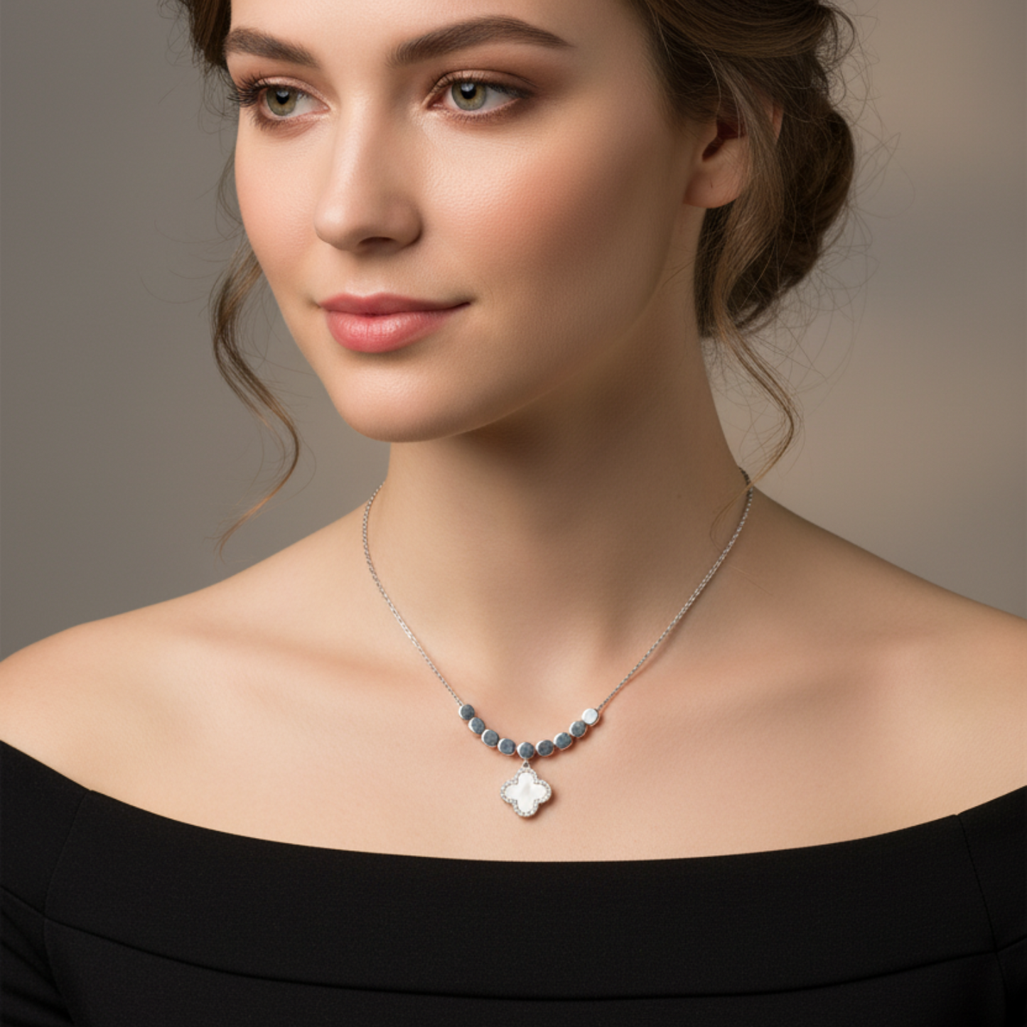 Woman wearing a necklace with a flower pendant against a neutral background