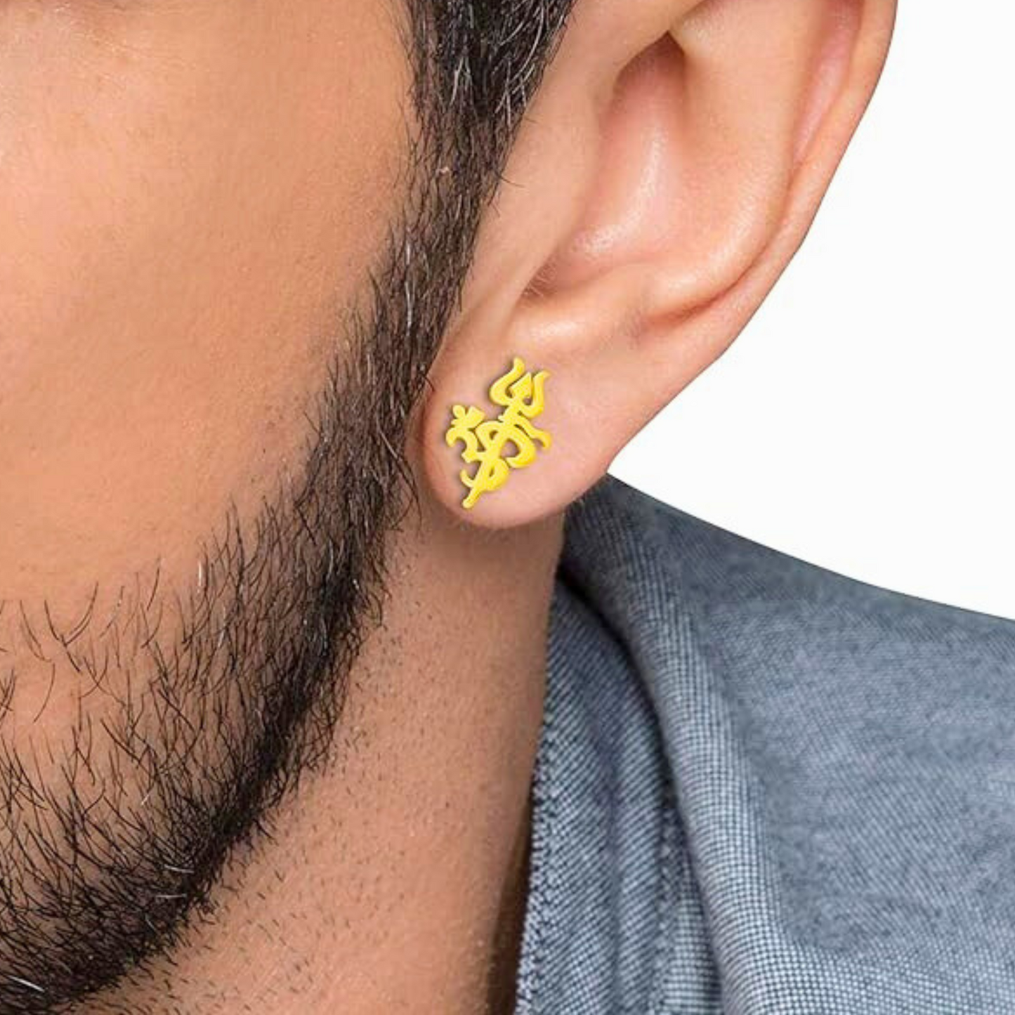Close-up of a man wearing gold om stud earrings with a white background