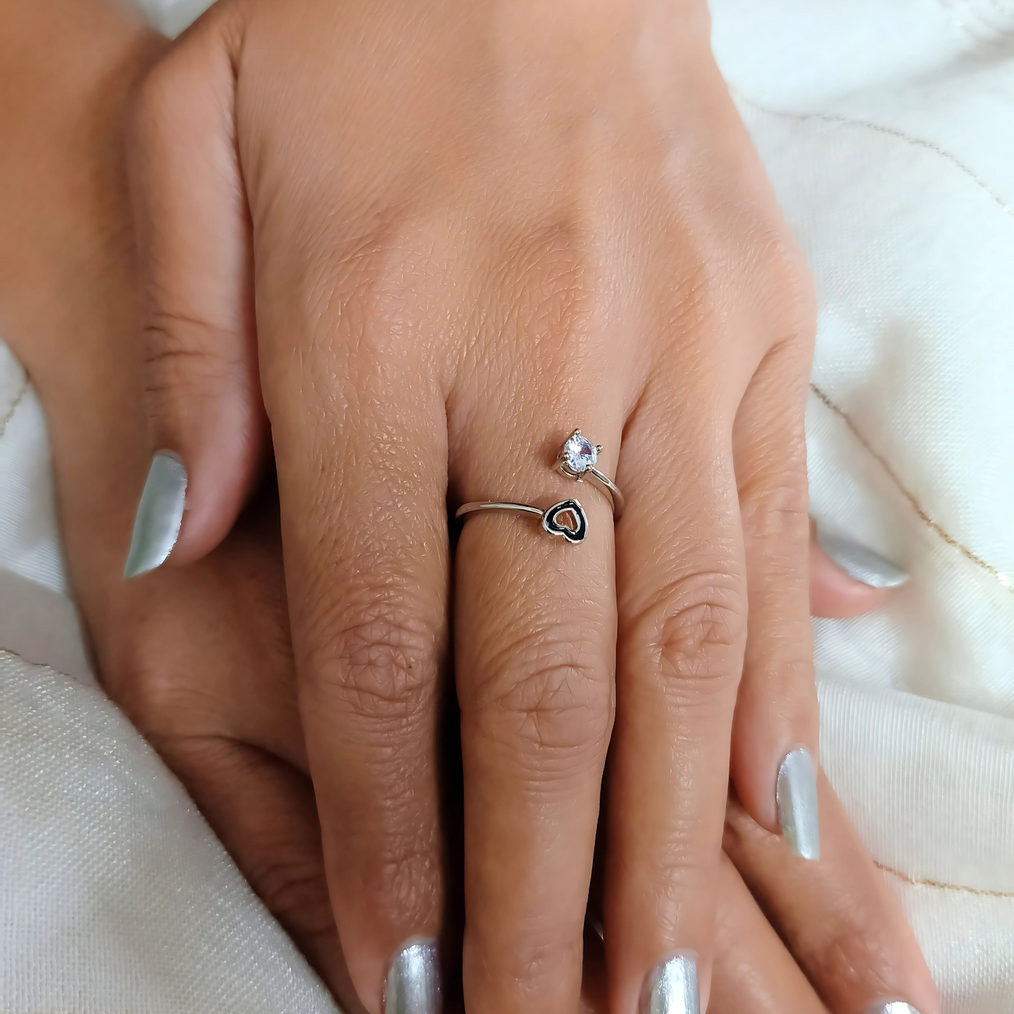 Close-up of a hand wearing two rings on a light background