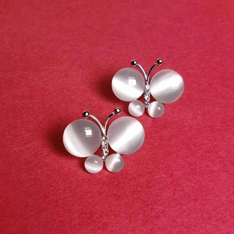 Butterfly-shaped jewelry with white stones on a red background