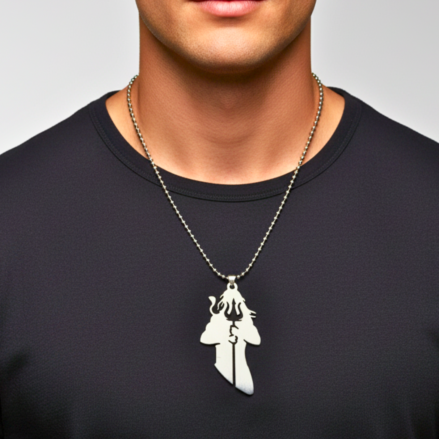 Man wearing a black shirt with a silver necklace featuring a unique pendant.