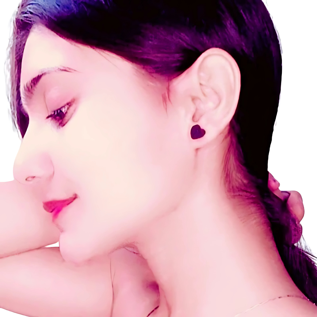 Close-up of a person wearing a heart-shaped earring with a blurred background