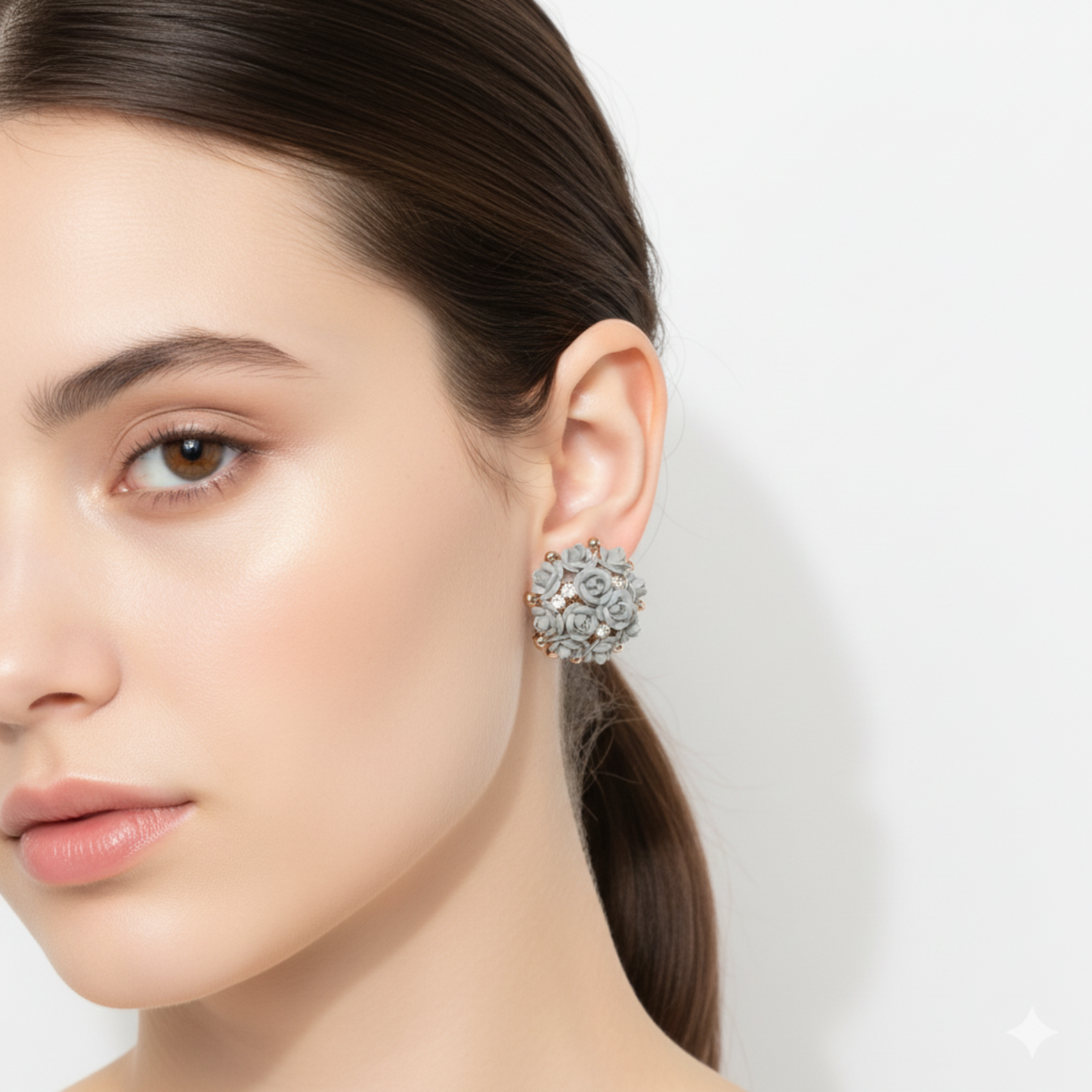 Close-up of a woman wearing a decorative earring on a plain background