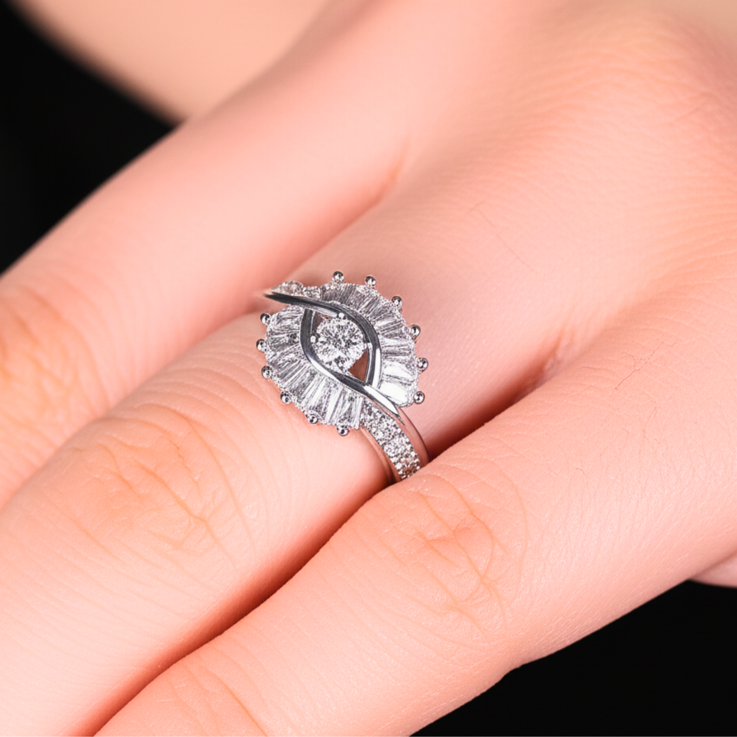 Silver ring with a diamond on a person's finger against a black background