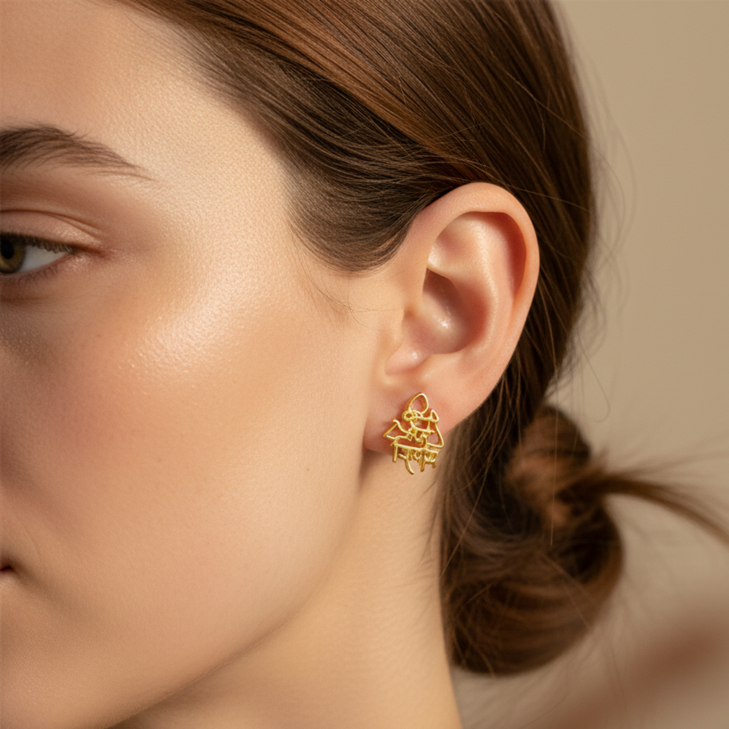 Close-up of a person wearing a gold earring with a blurred background
