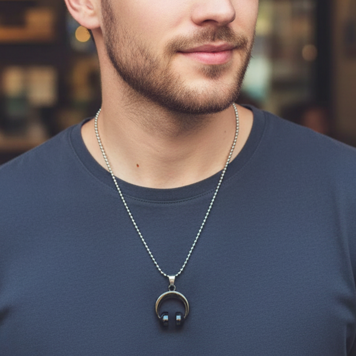 Man wearing a necklace with a pendant in an urban setting