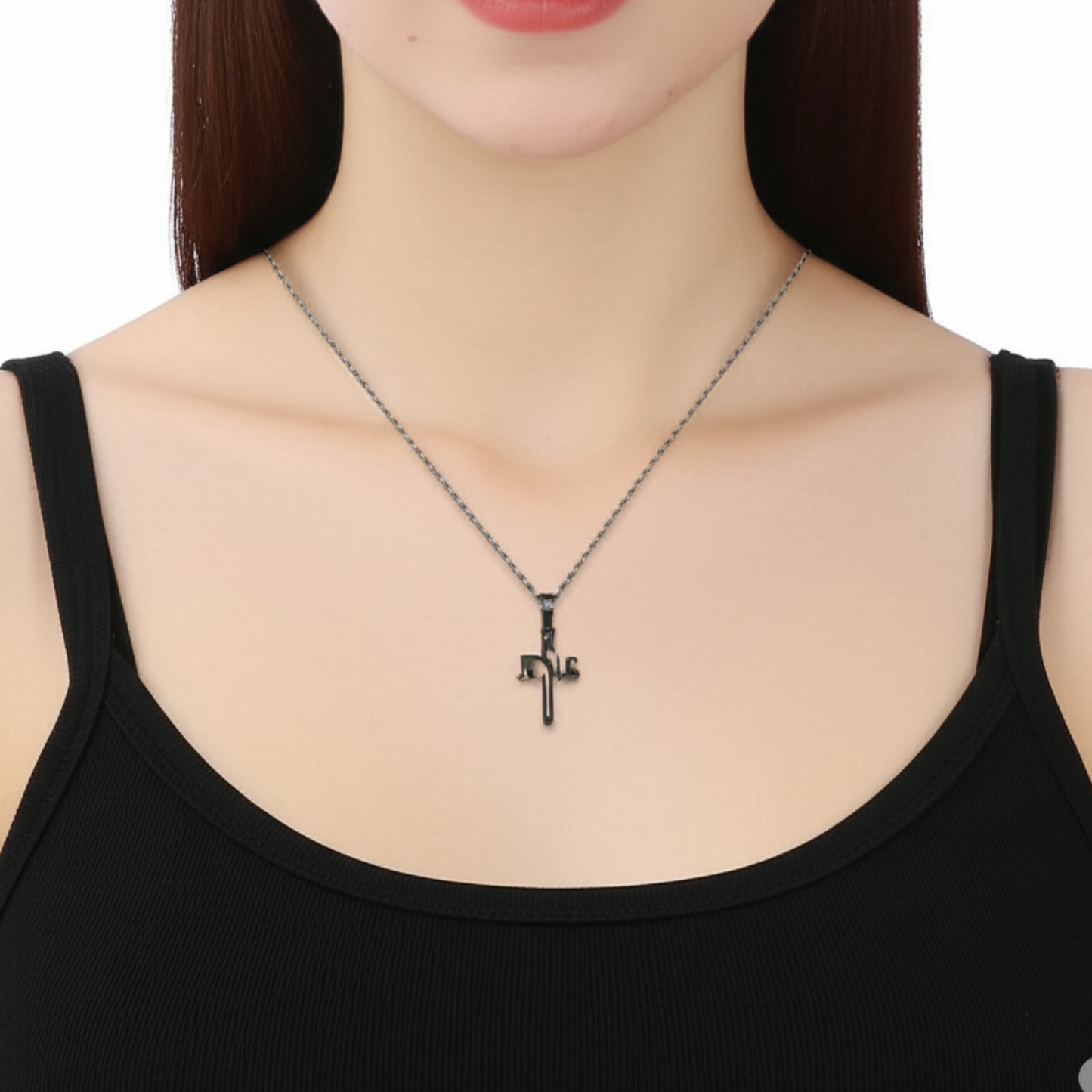 Person wearing a black cross necklace on a plain background