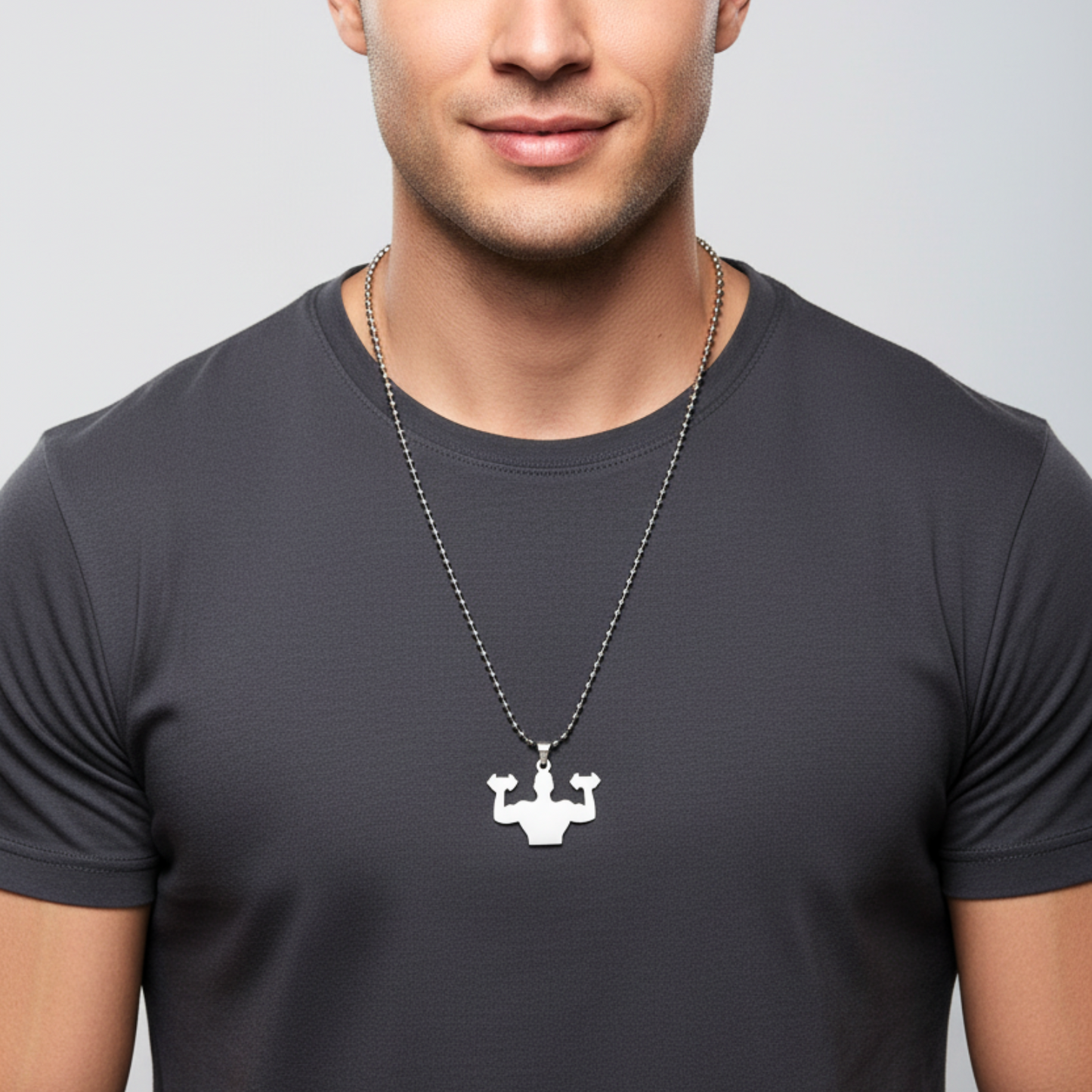 Man wearing a black t-shirt with a necklace featuring a unique pendant on a plain background