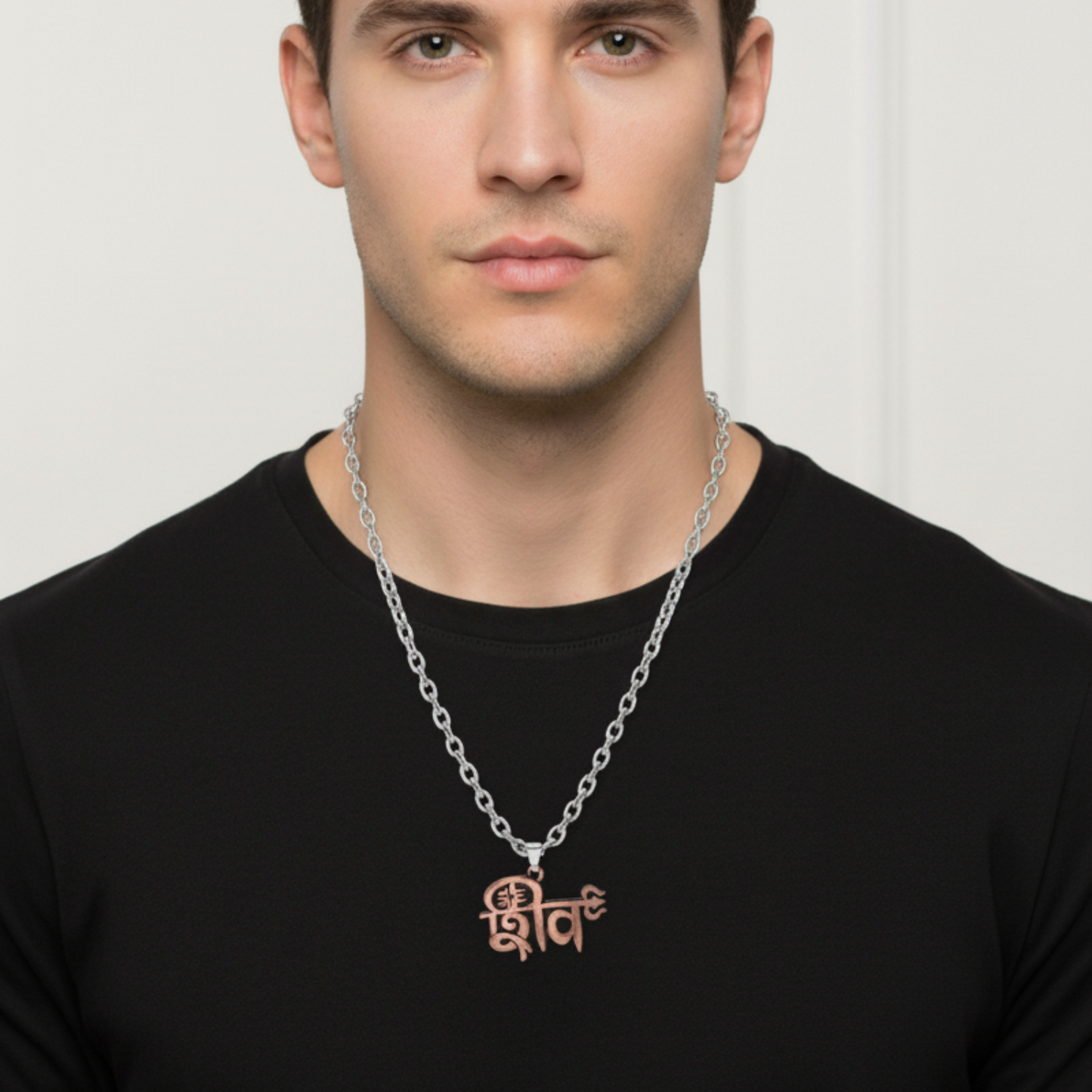 Man wearing a black shirt with a silver chain necklace featuring a brown pendant.