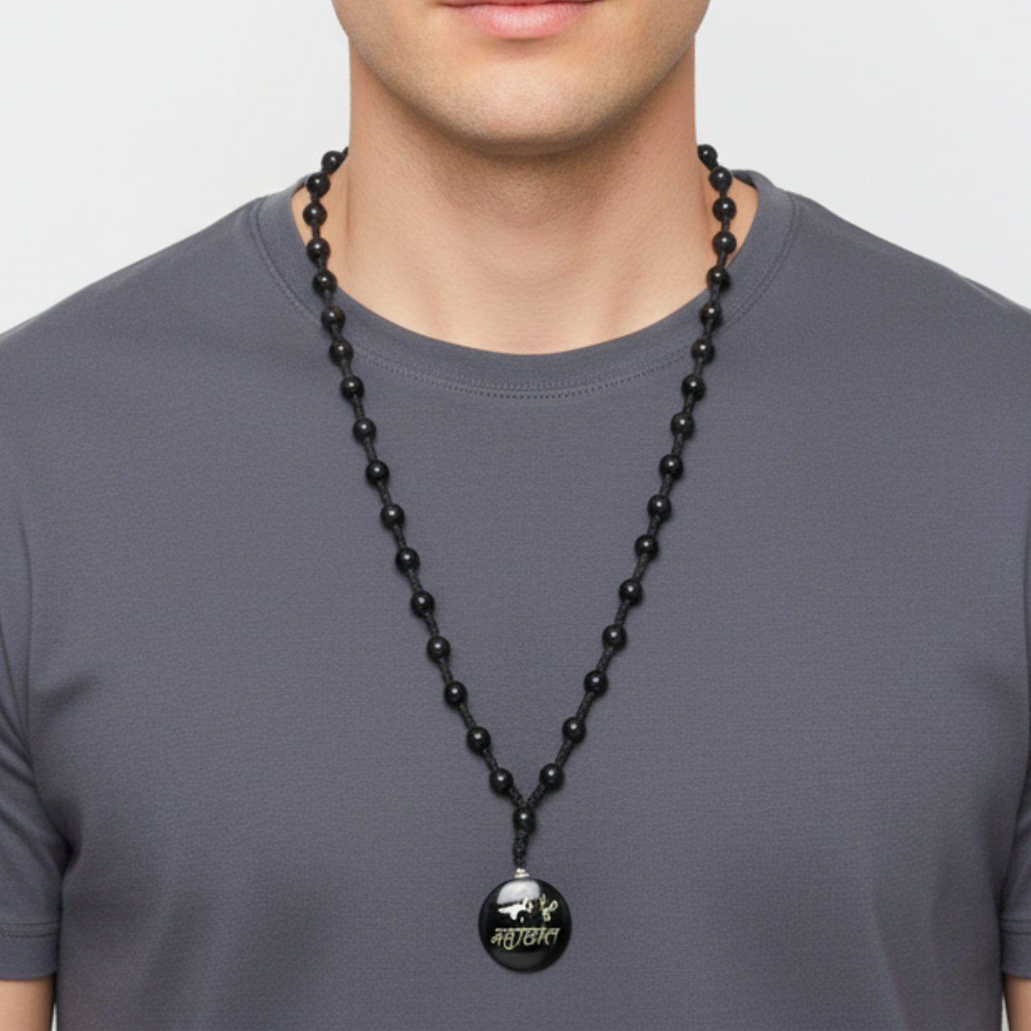 Man wearing a black beaded necklace with a pendant on a plain background
