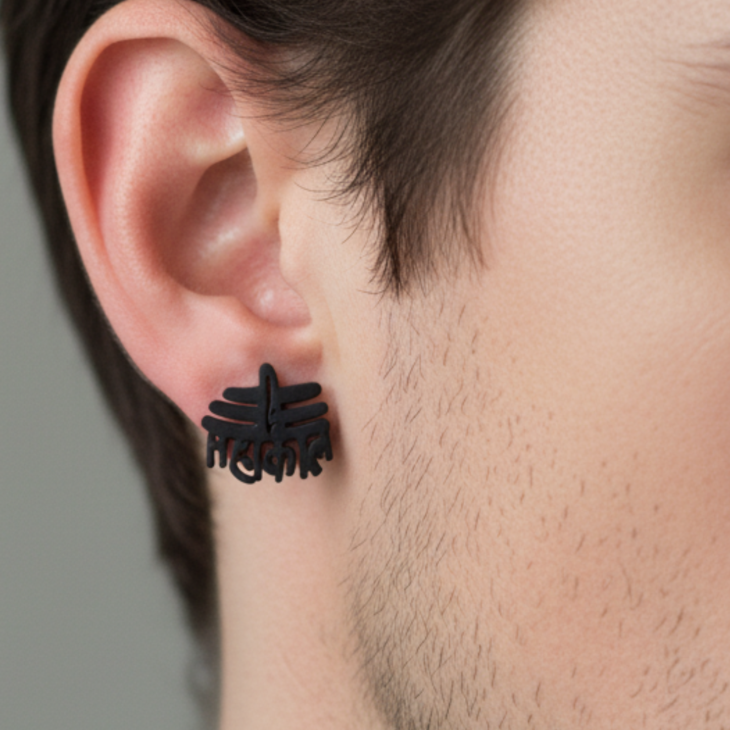 Black floral earring worn by a person with a neutral background
