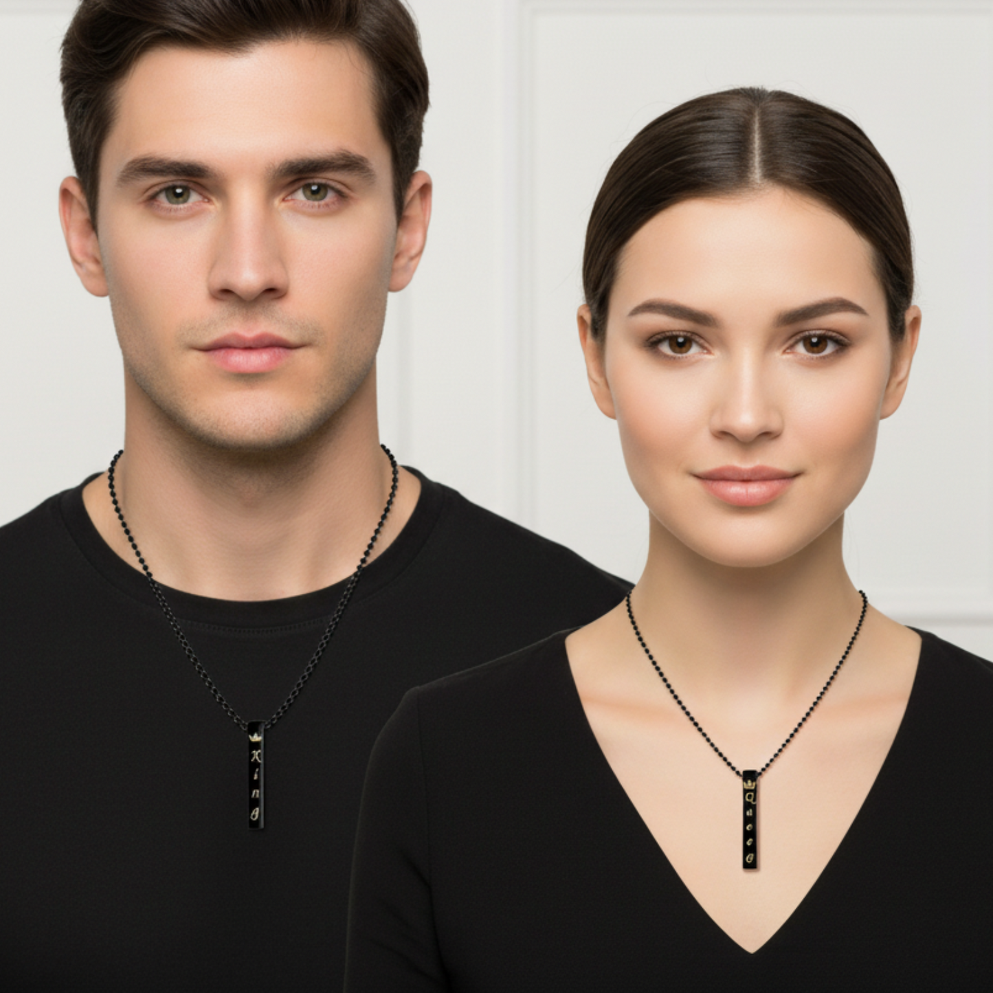 Man and woman wearing black necklaces with a white background