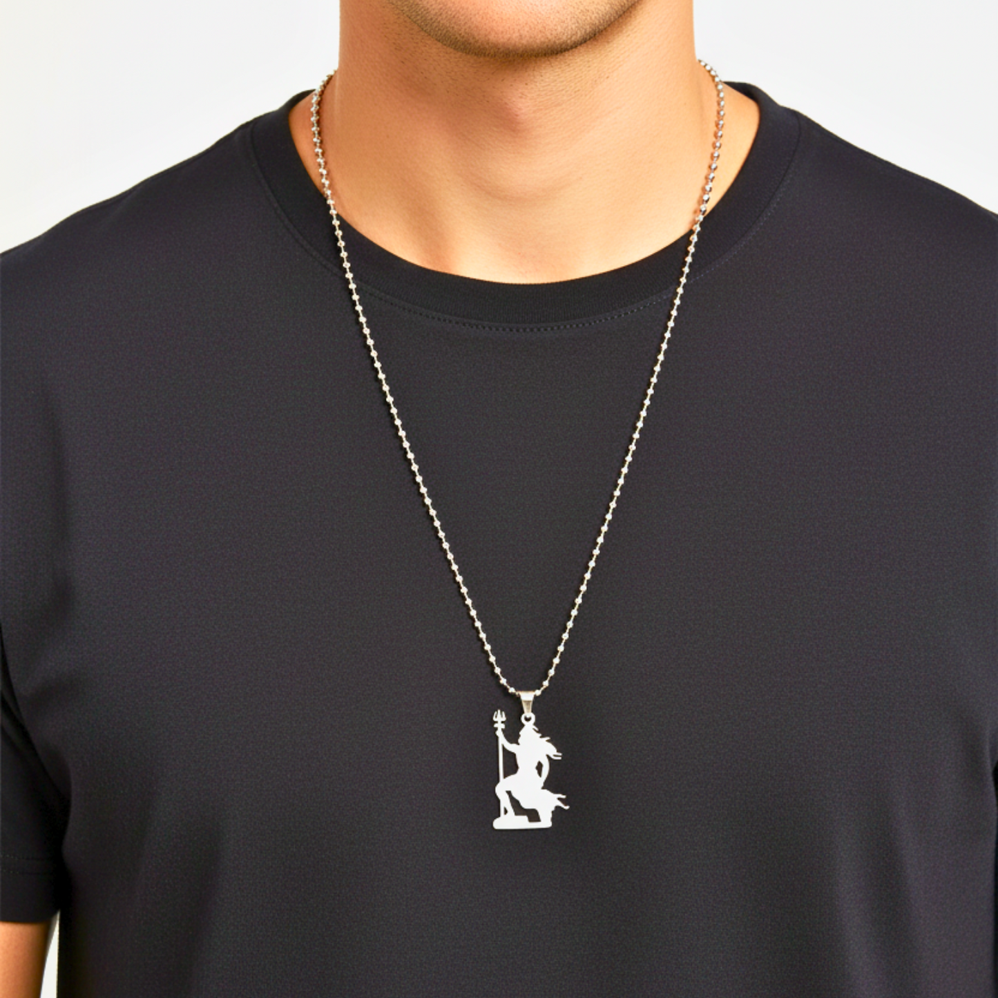 Person wearing a black shirt with a silver necklace featuring a pendant.