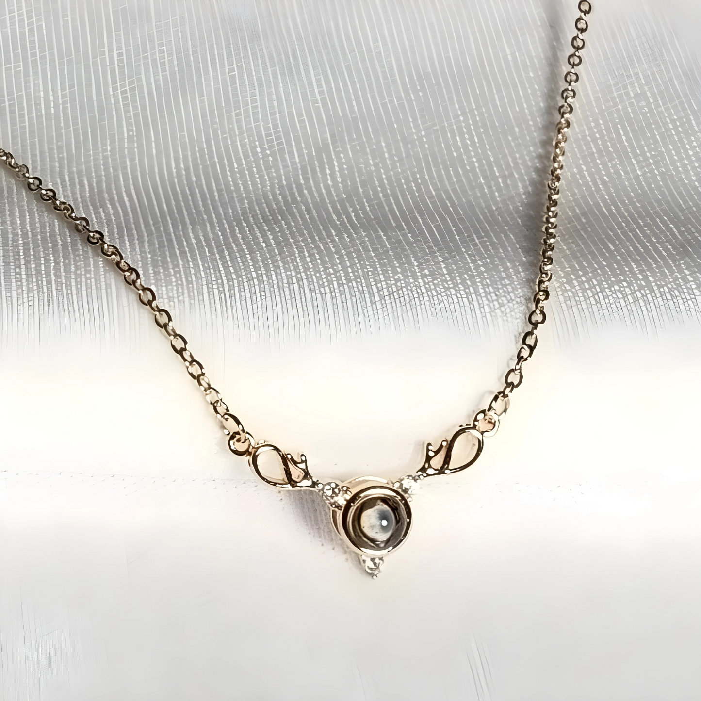 Gold necklace with a circular pendant on a white fabric background
