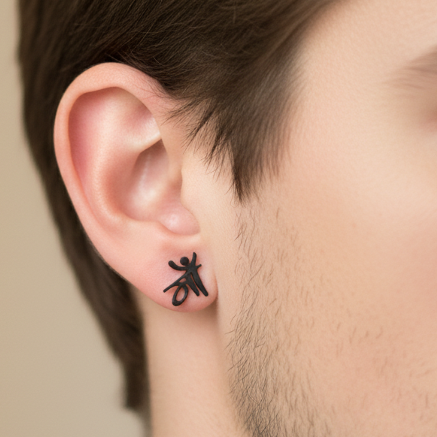 Person wearing a black spider-shaped earring on an ear with a neutral background