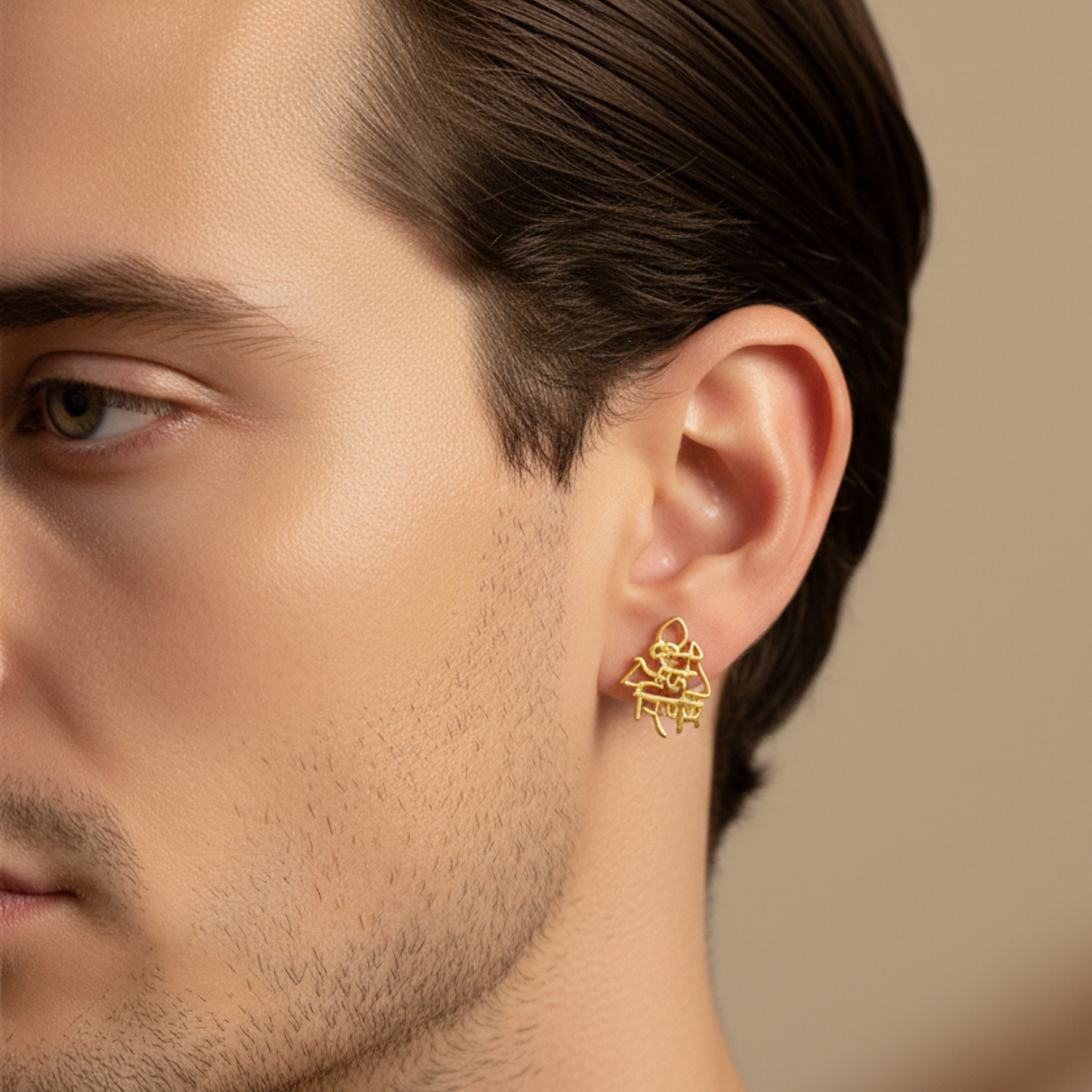Close-up of a man wearing a gold earring with a blurred background