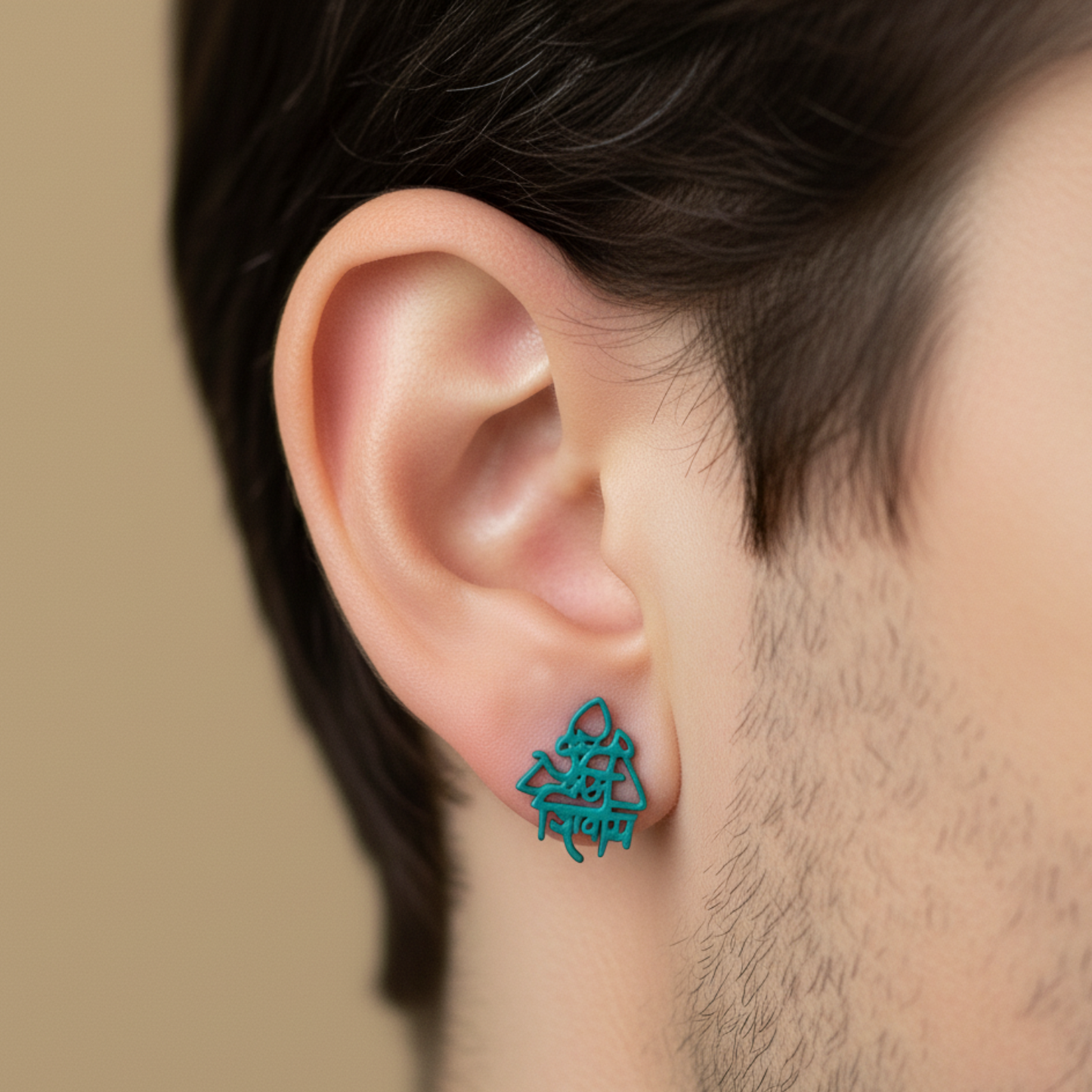 Close-up of an ear wearing a turquoise geometric earring against a neutral background