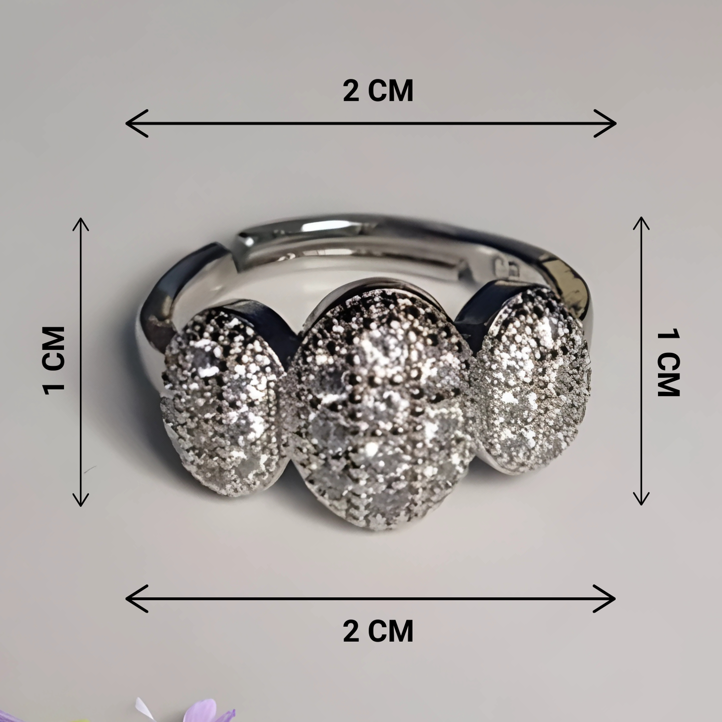 Silver ring with three circular gemstones, shown with measurements on a gray background