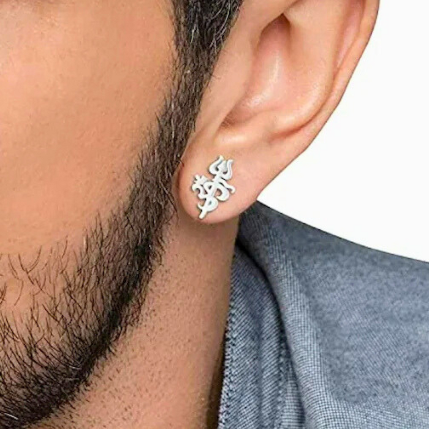 Silver ear cuff worn by a person with a neutral background