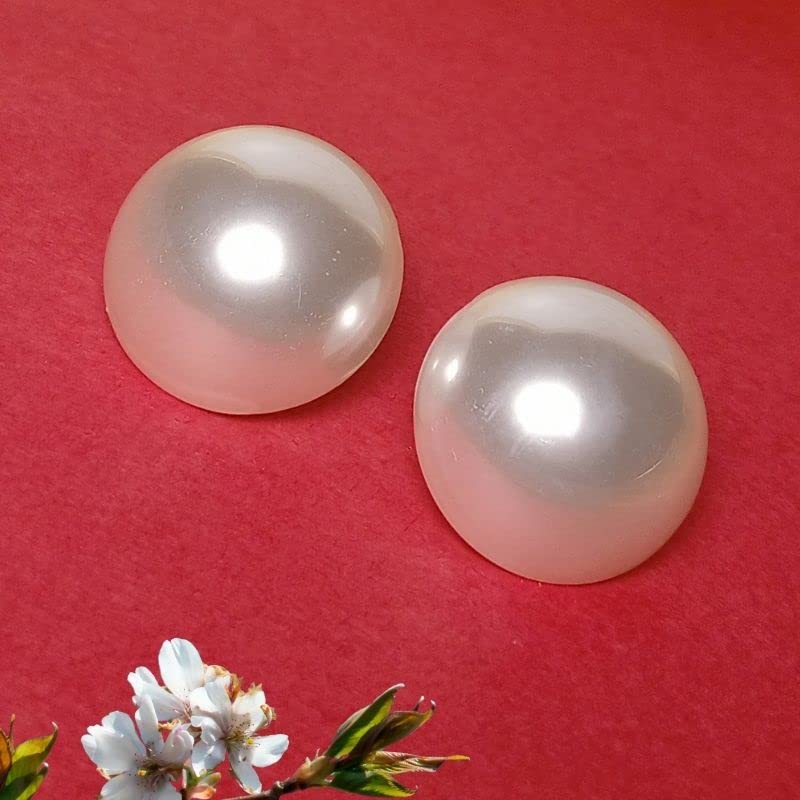 Two pearls on a red background with a small white flower at the bottom left corner.