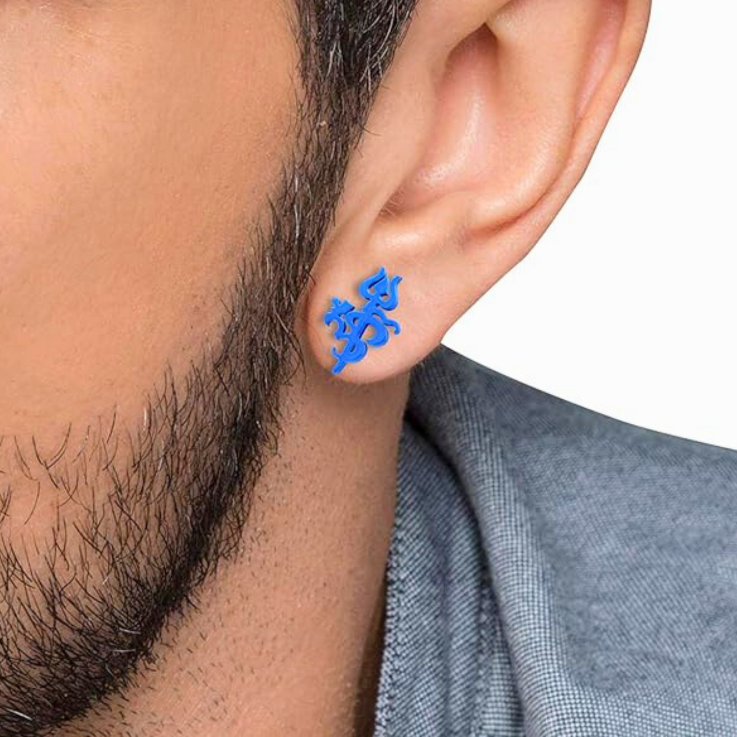 Blue om trishul earrings worn by a person with a neutral background