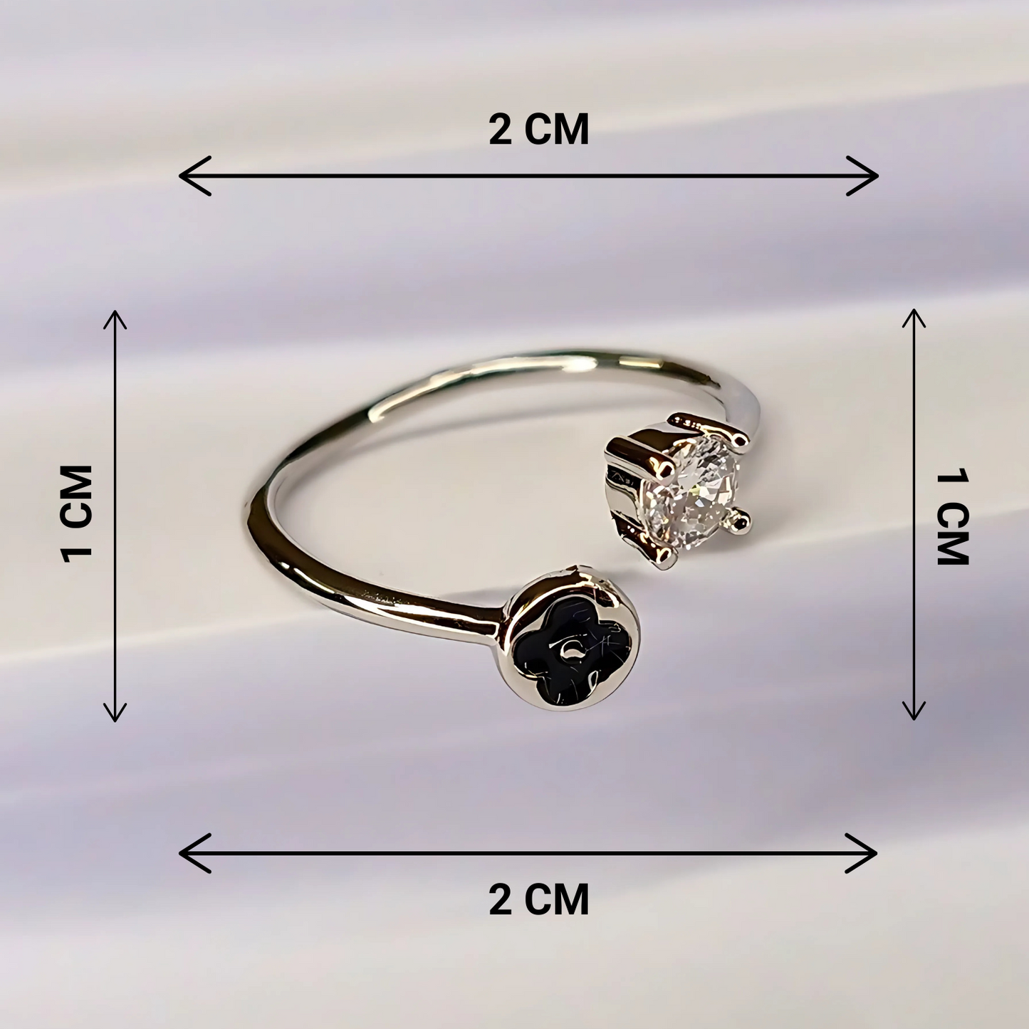 Gold earring with black flower design and clear gemstone, shown with measurements on a white background.