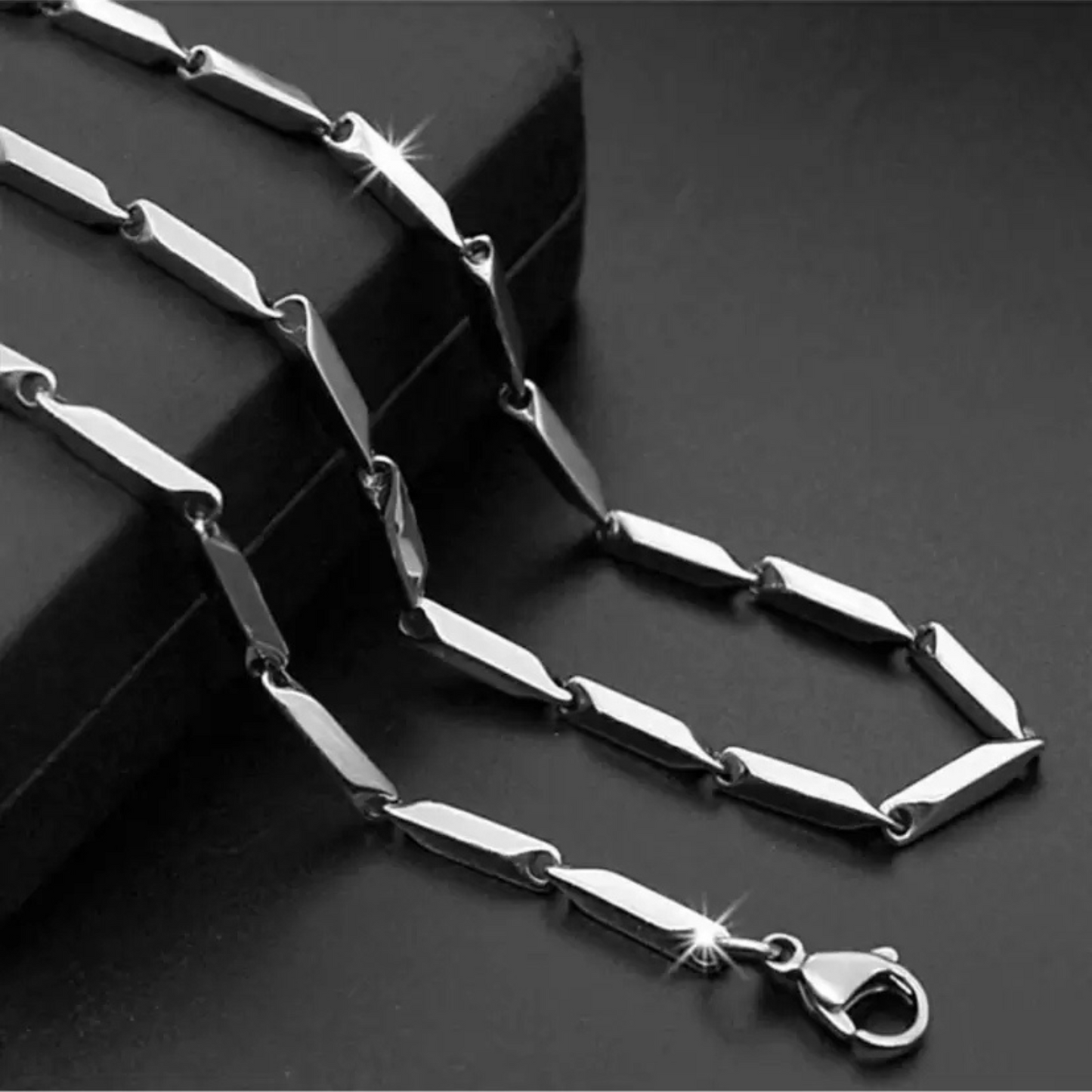 Silver chain necklace on a dark surface