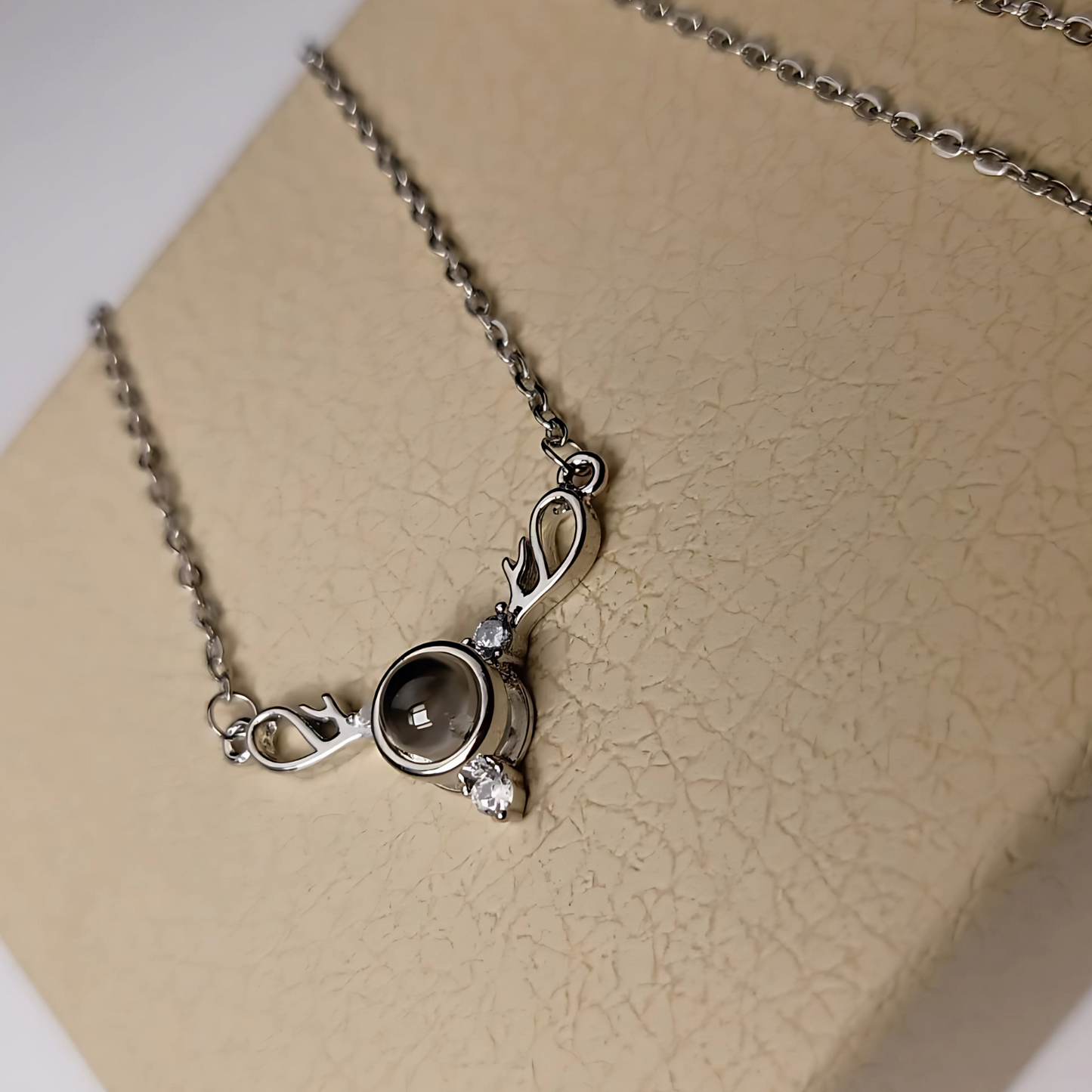 Silver necklace with a pendant on a beige background