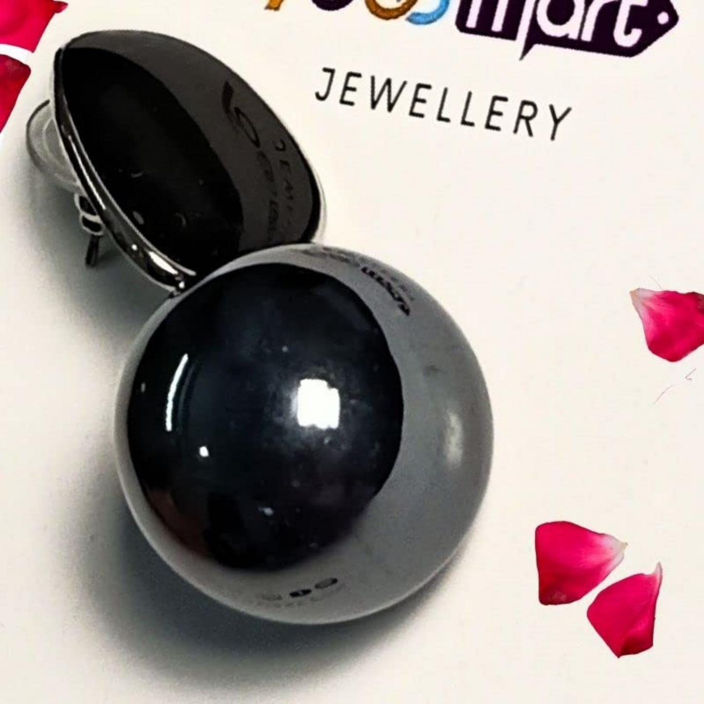 Black sphere with a white base on a white background with red petals, featuring 'Jewellery' branding.