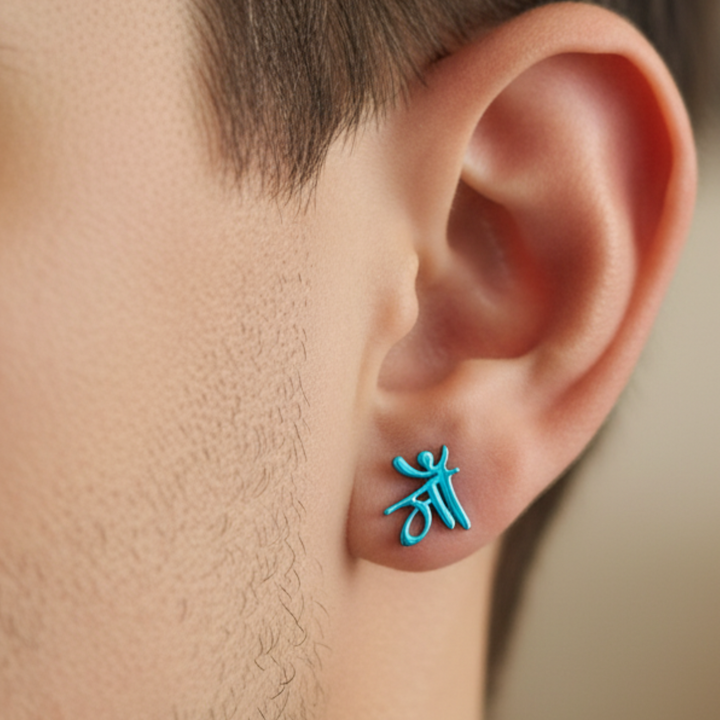 Turquoise earring worn on a person's ear with a neutral background