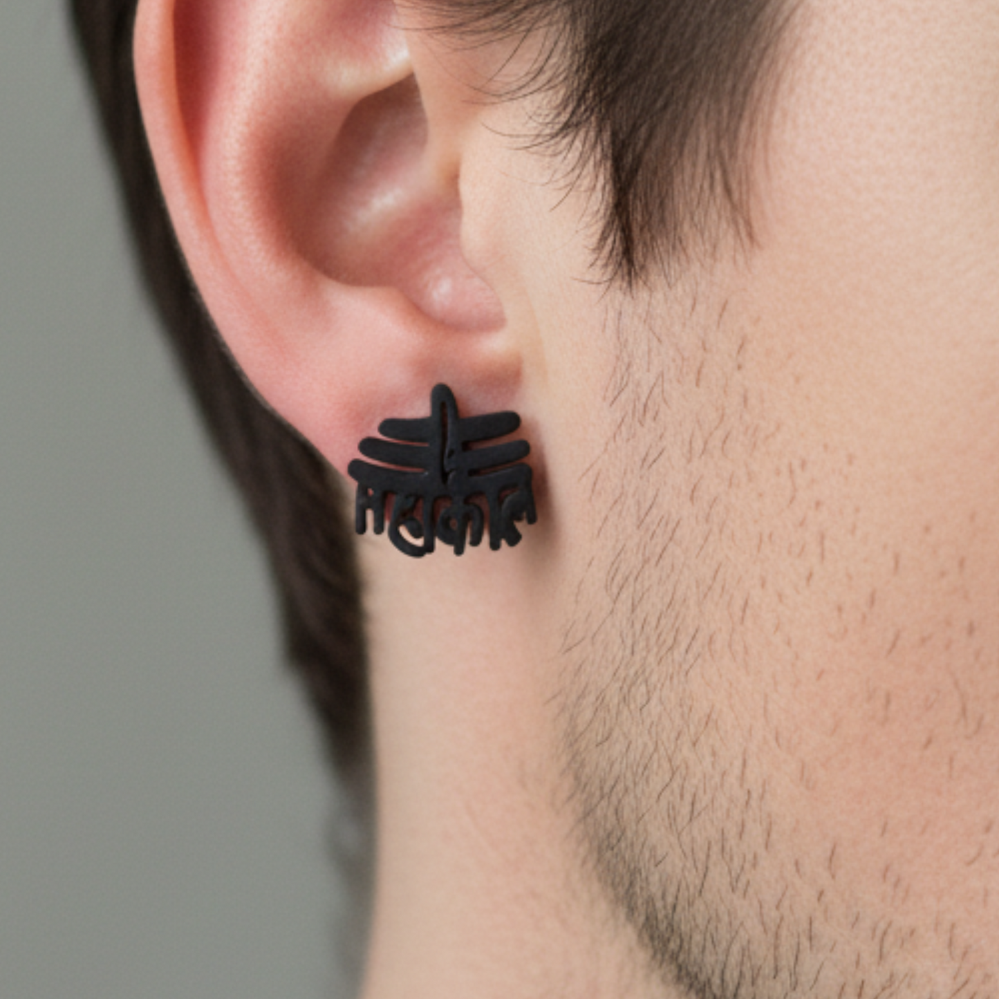 Black floral earring worn by a person with a neutral background