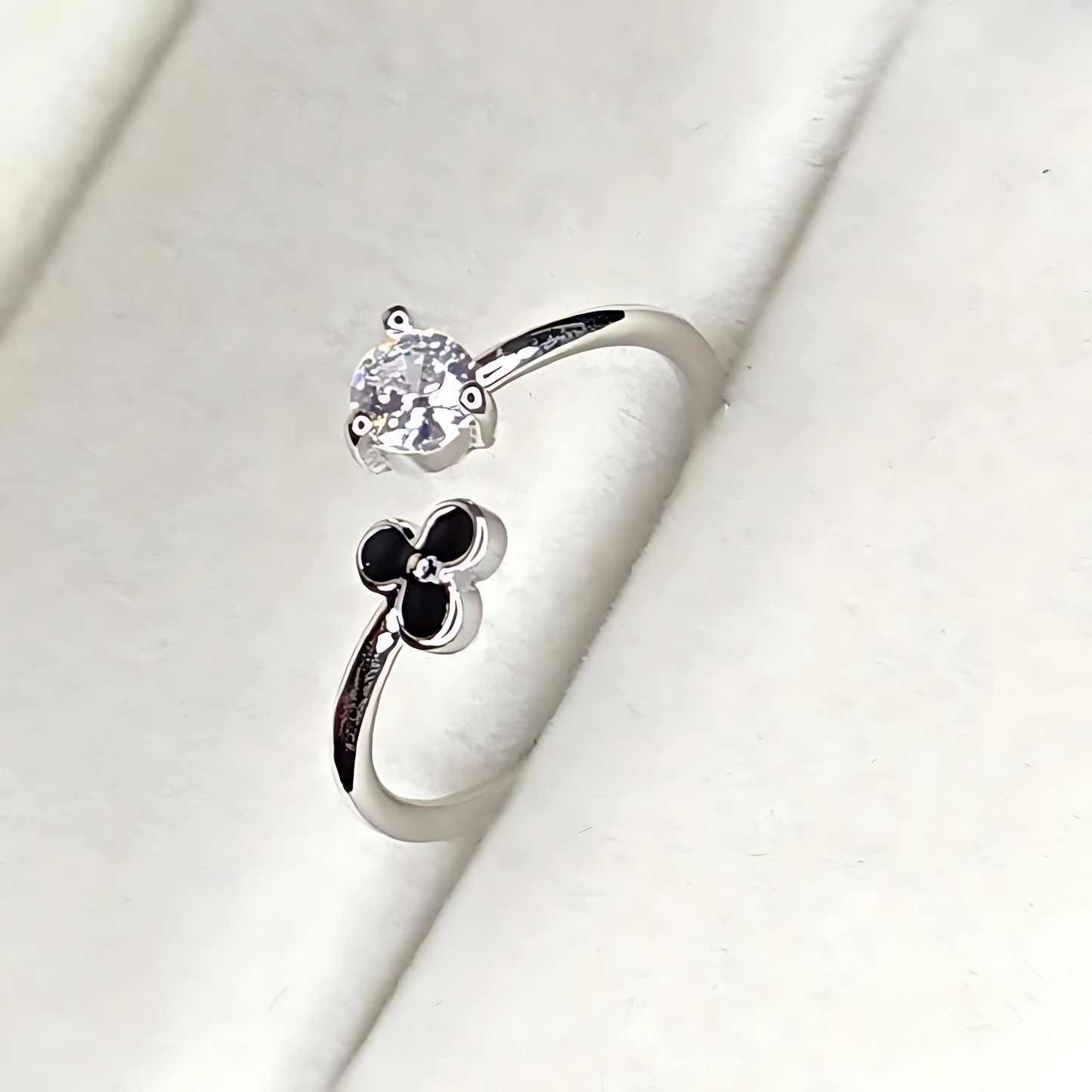 Silver ring with a flower design on a white background