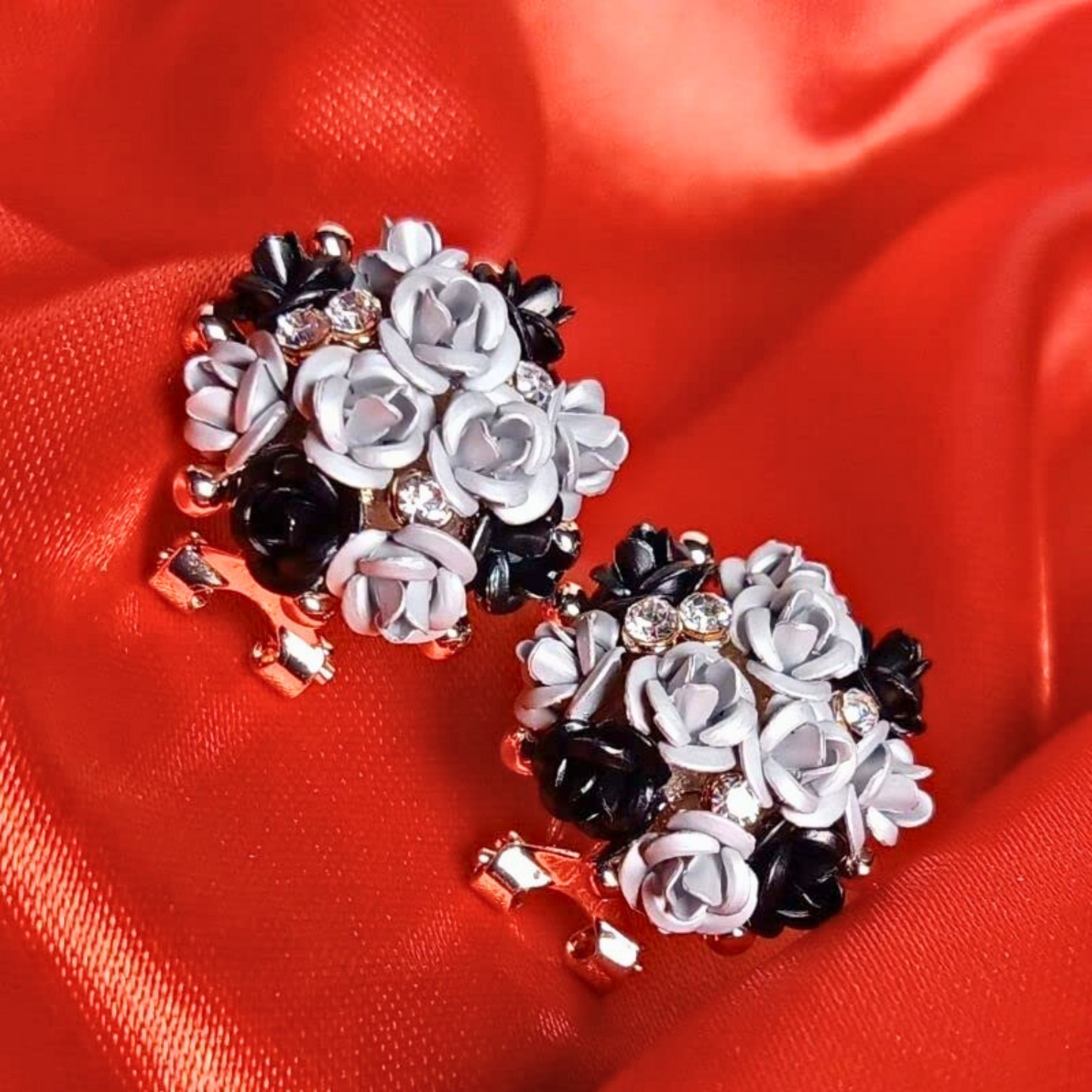 Pair of floral earrings on a red fabric background