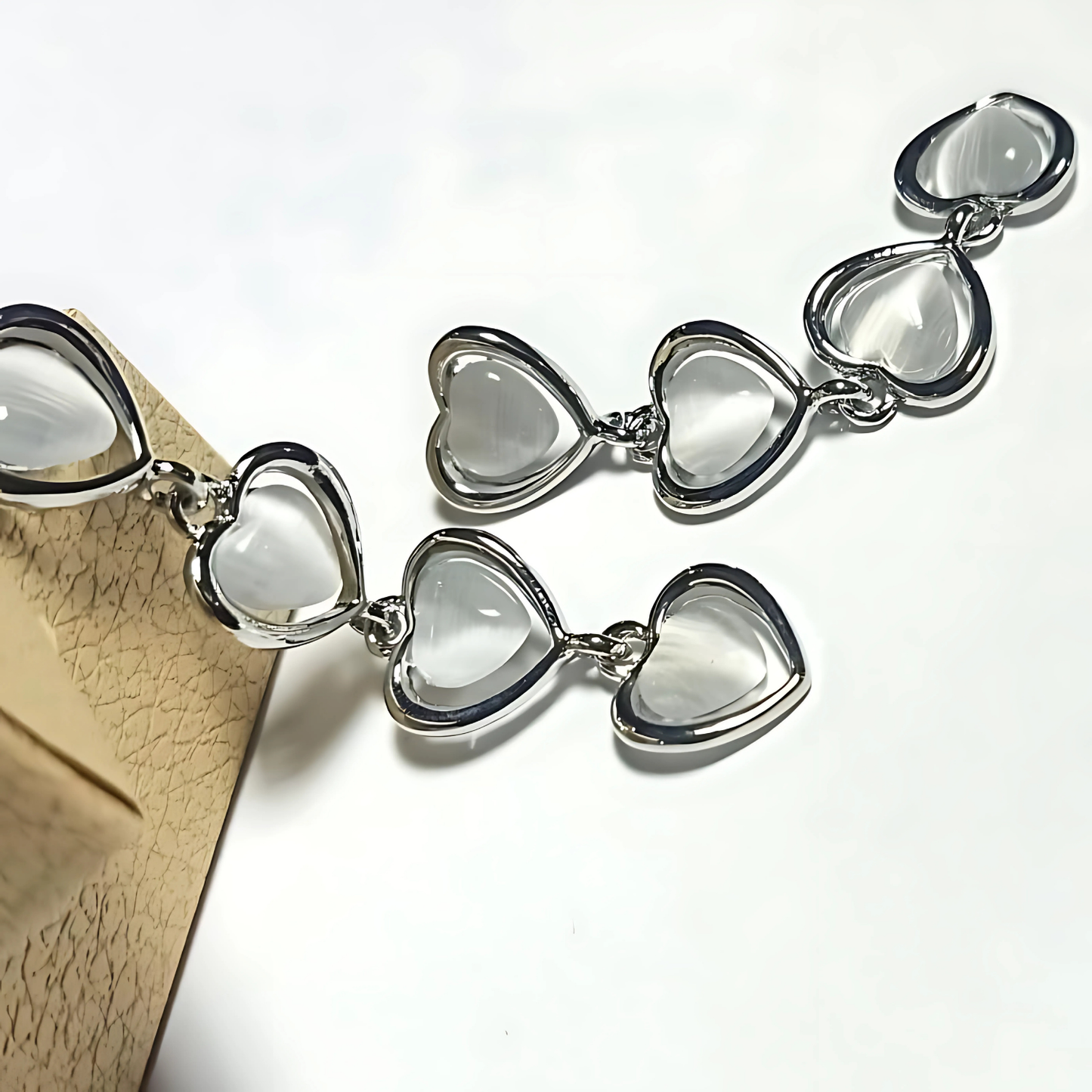 Silver bracelet with heart-shaped clear stones on a light background