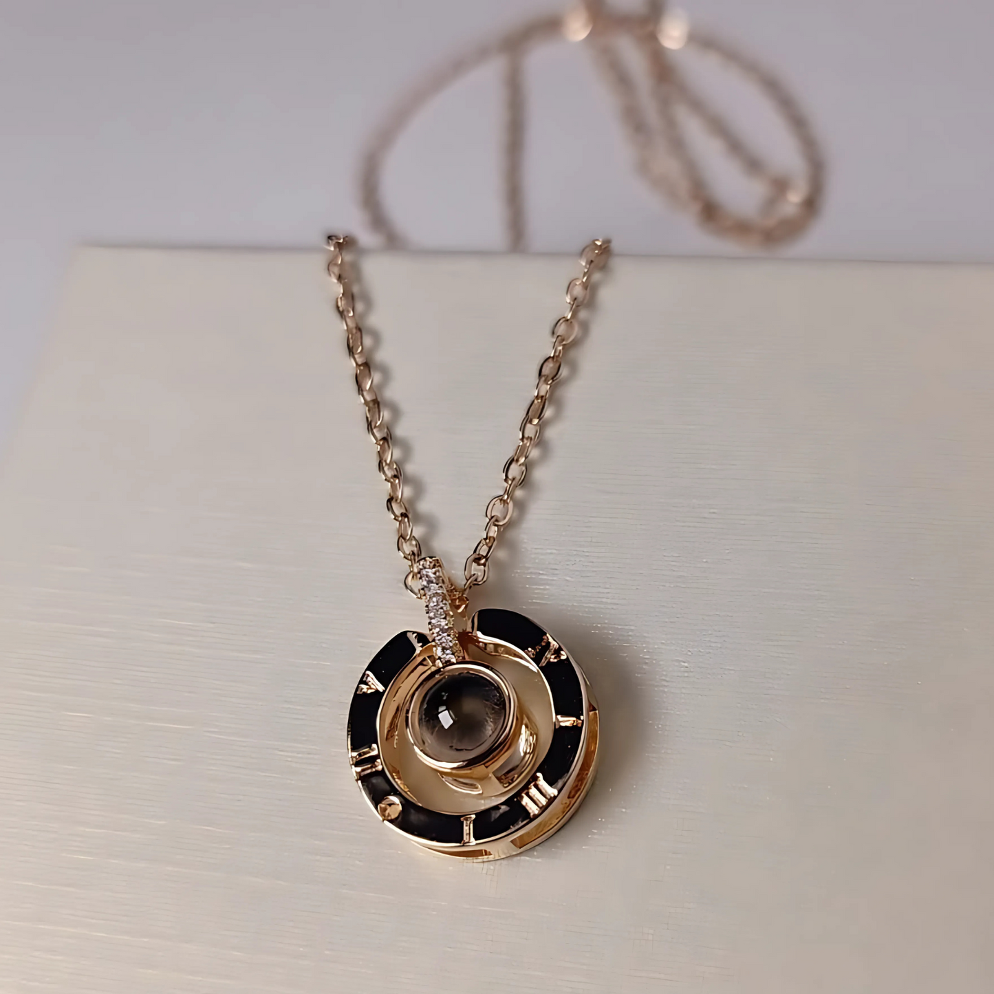 Gold and black pendant necklace on a light background