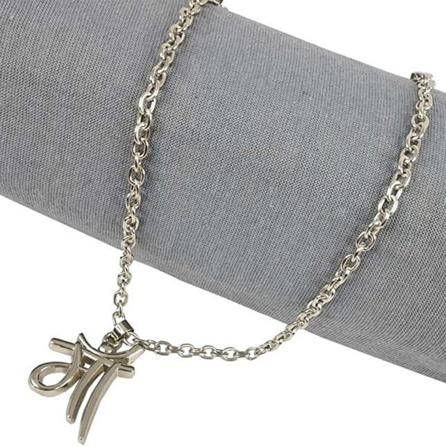 Silver necklace with a unique pendant on a gray fabric background