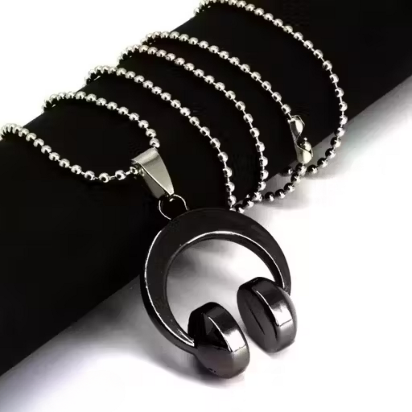 Black and silver pendant necklace on a black background
