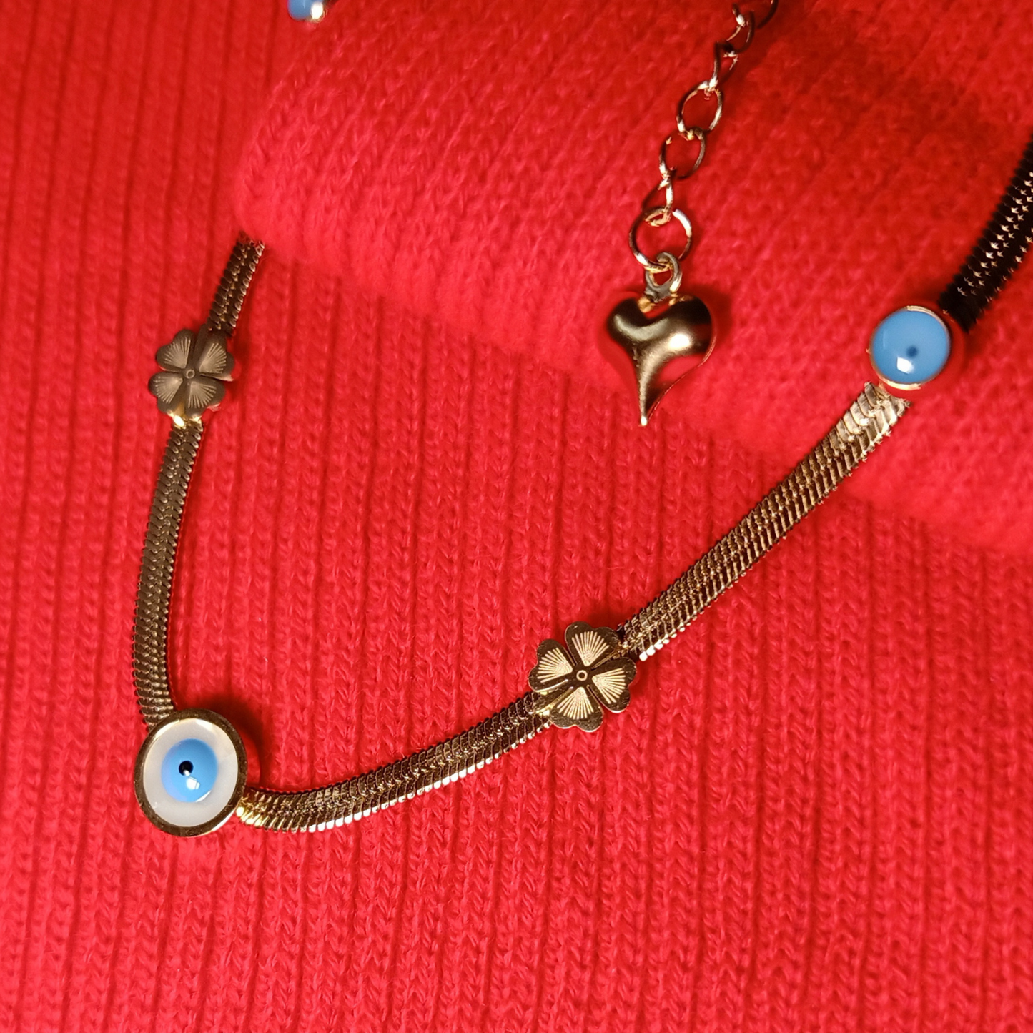 Bracelet with floral and heart charms on a red textured background
