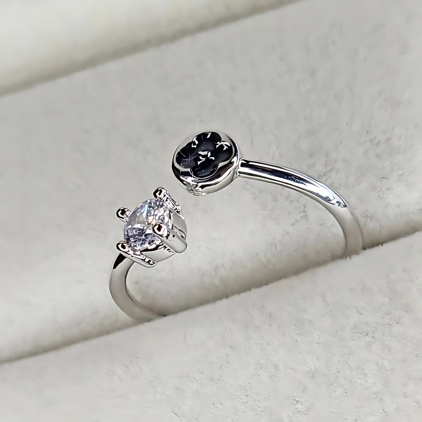 Silver ring with a pear-shaped gemstone on a light gray background